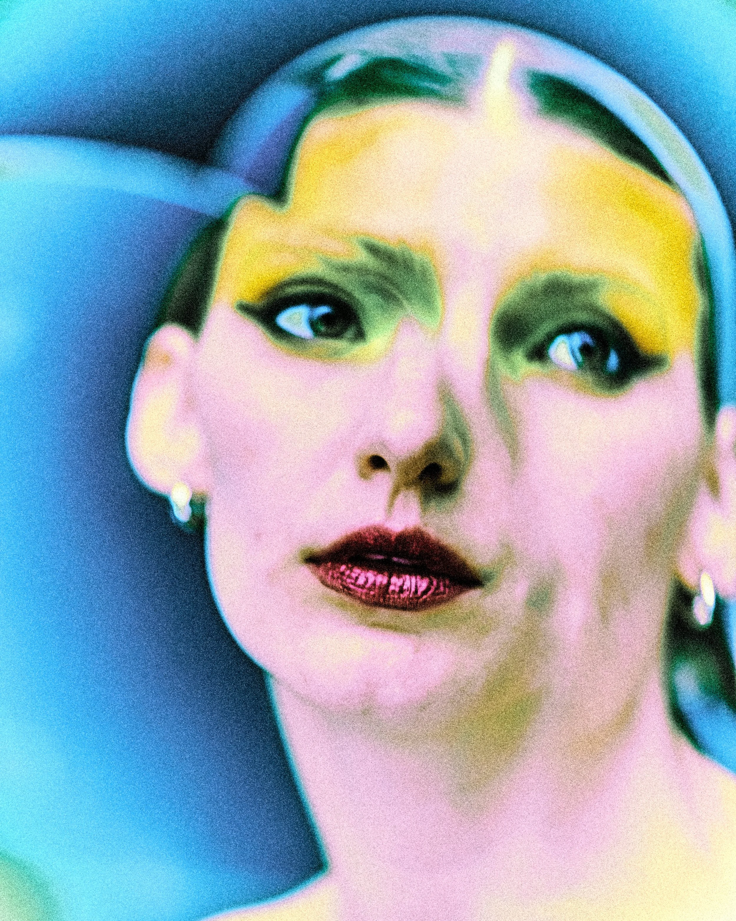 A close-up of a woman with colorful makeup, large dark eyeliner, and lipstick, wearing earrings, with her head tilted and partially visible face against a vibrant background.
