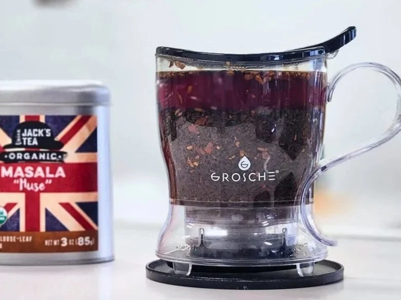 tea steeper with tea in it next to a tin from Union Jack's Tea with a british flag sticker on it