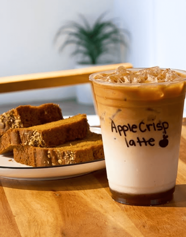 A seasonal latte sitting on the counter, one of the best coffee orders to try at a local cafe.
