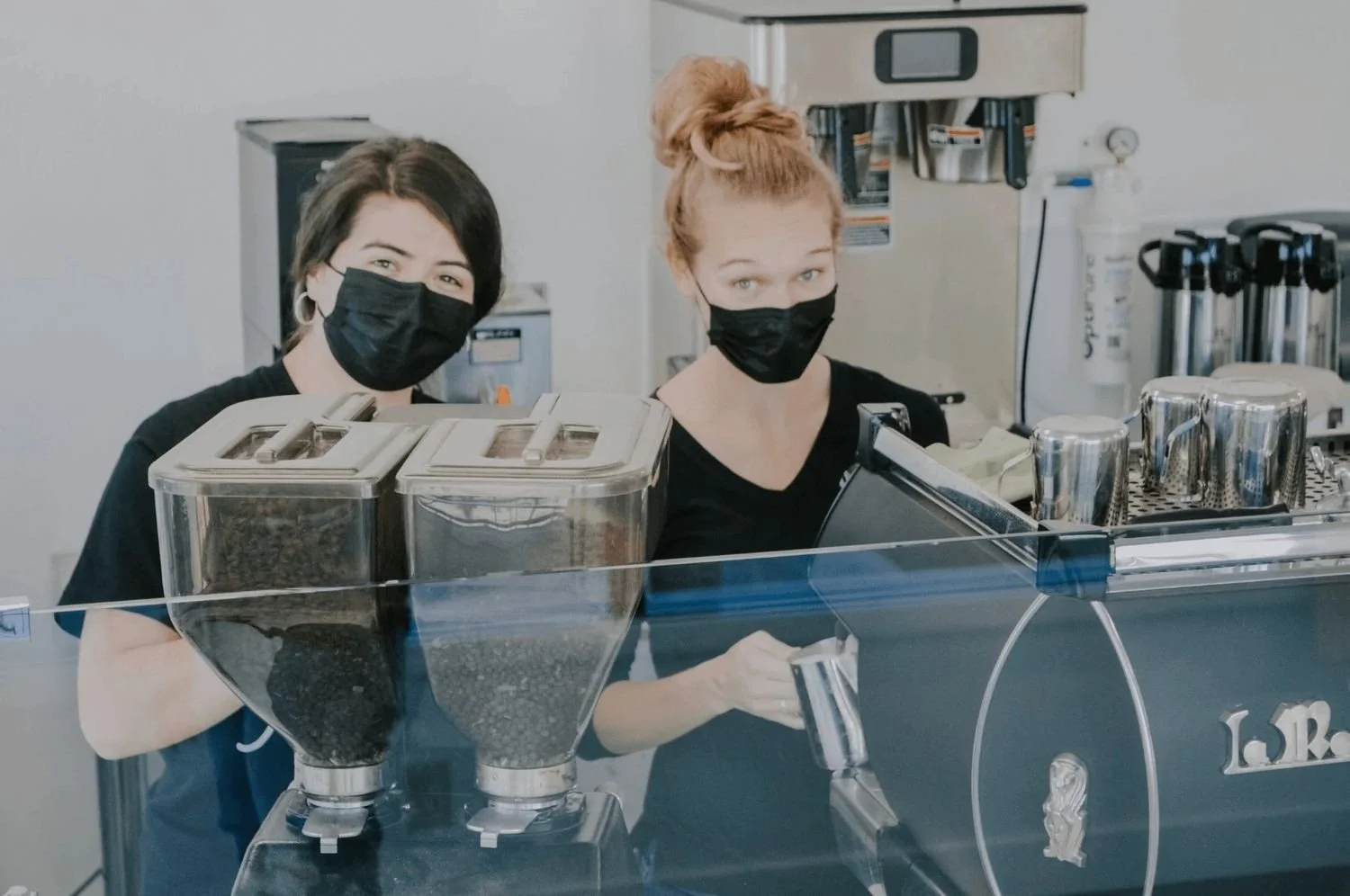 baristas smiling while making drinks opening day at Inicio
