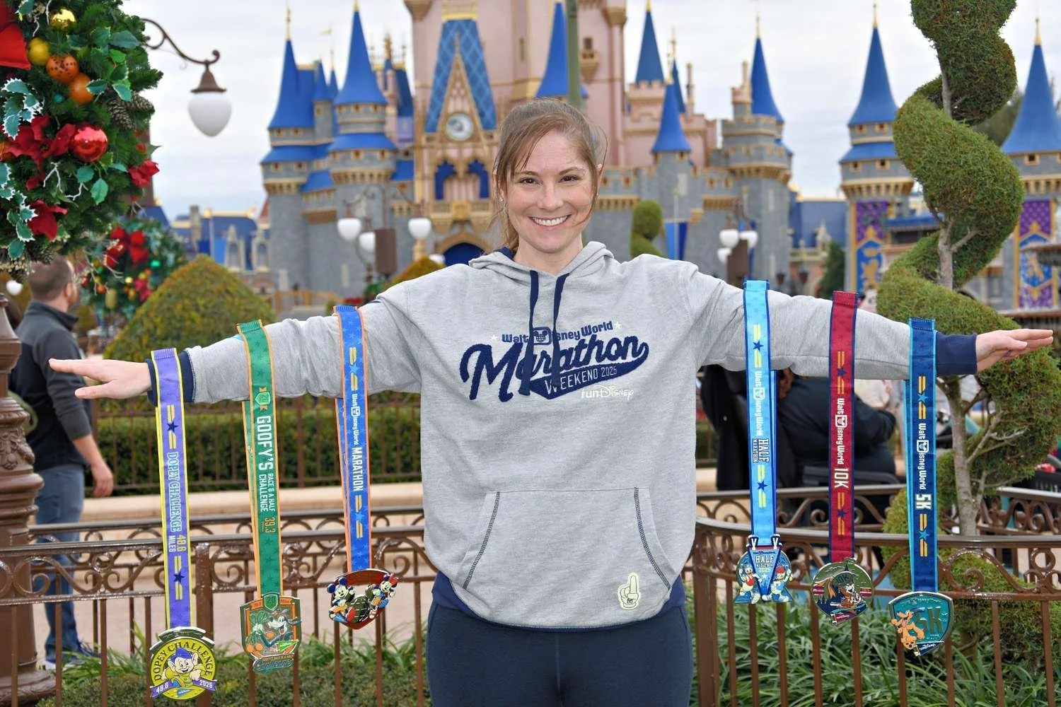Female runner holding up her Disney medals