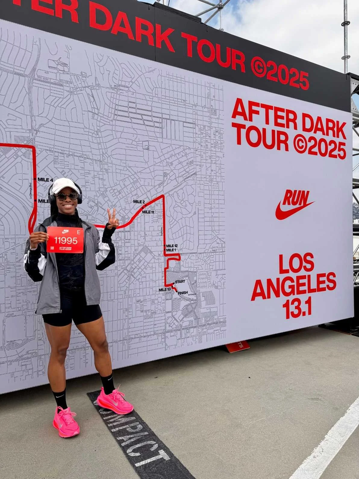 Black female runner holding a race bib