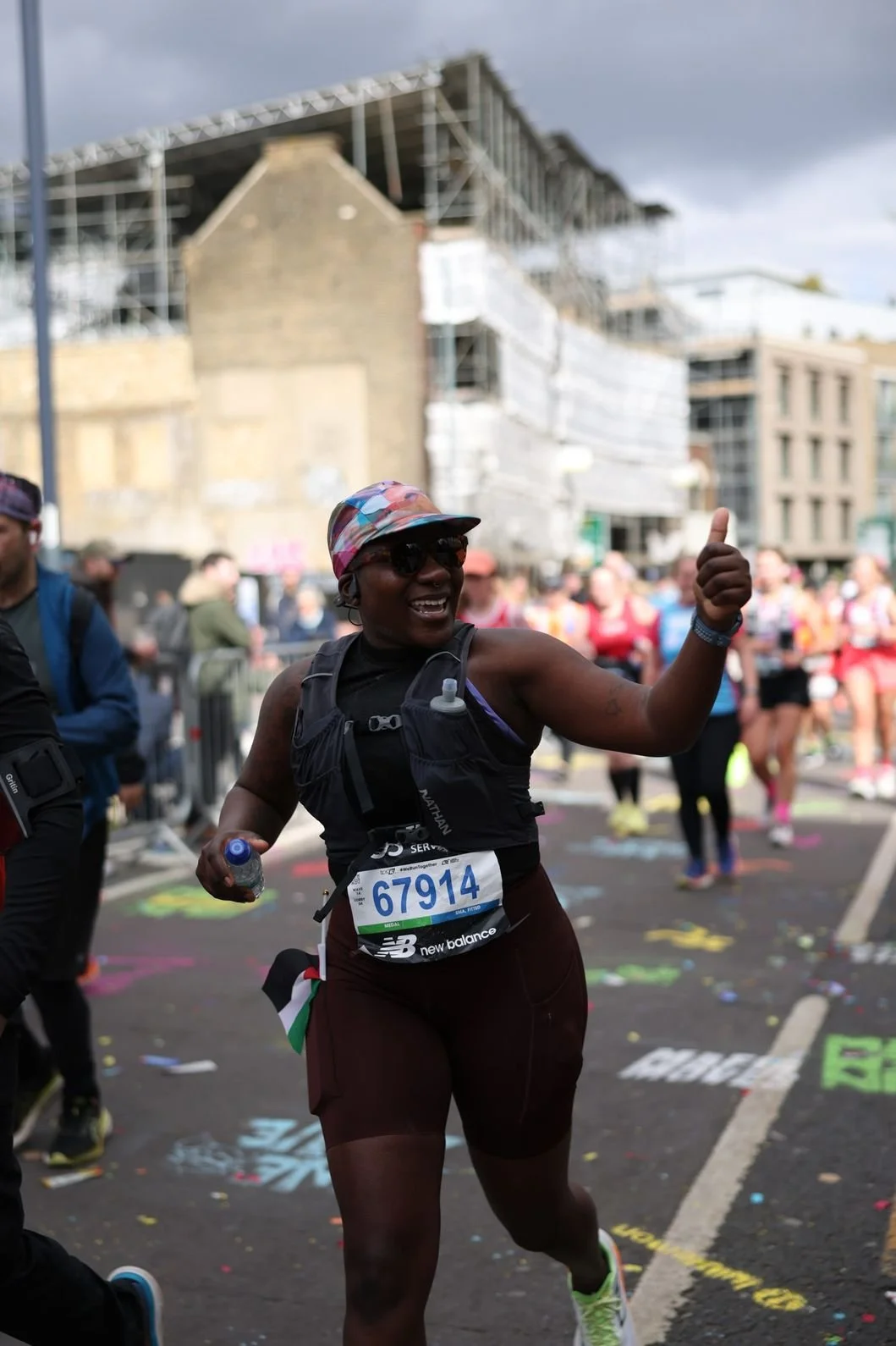 Black female athlete giving a thumbs up during a race