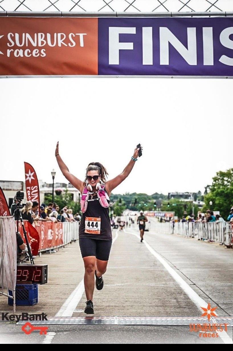 female runner crossing the finish line of a half marathon