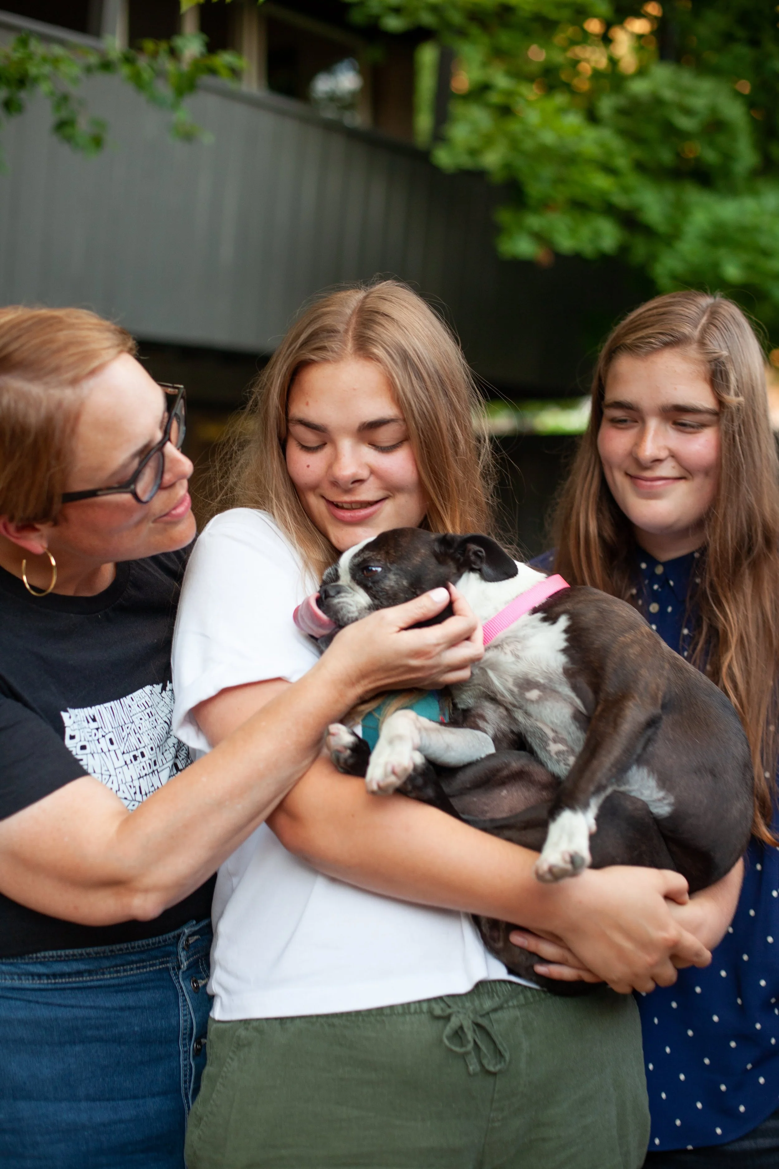 Amy, Lauren, Lily with Dot outdoors.