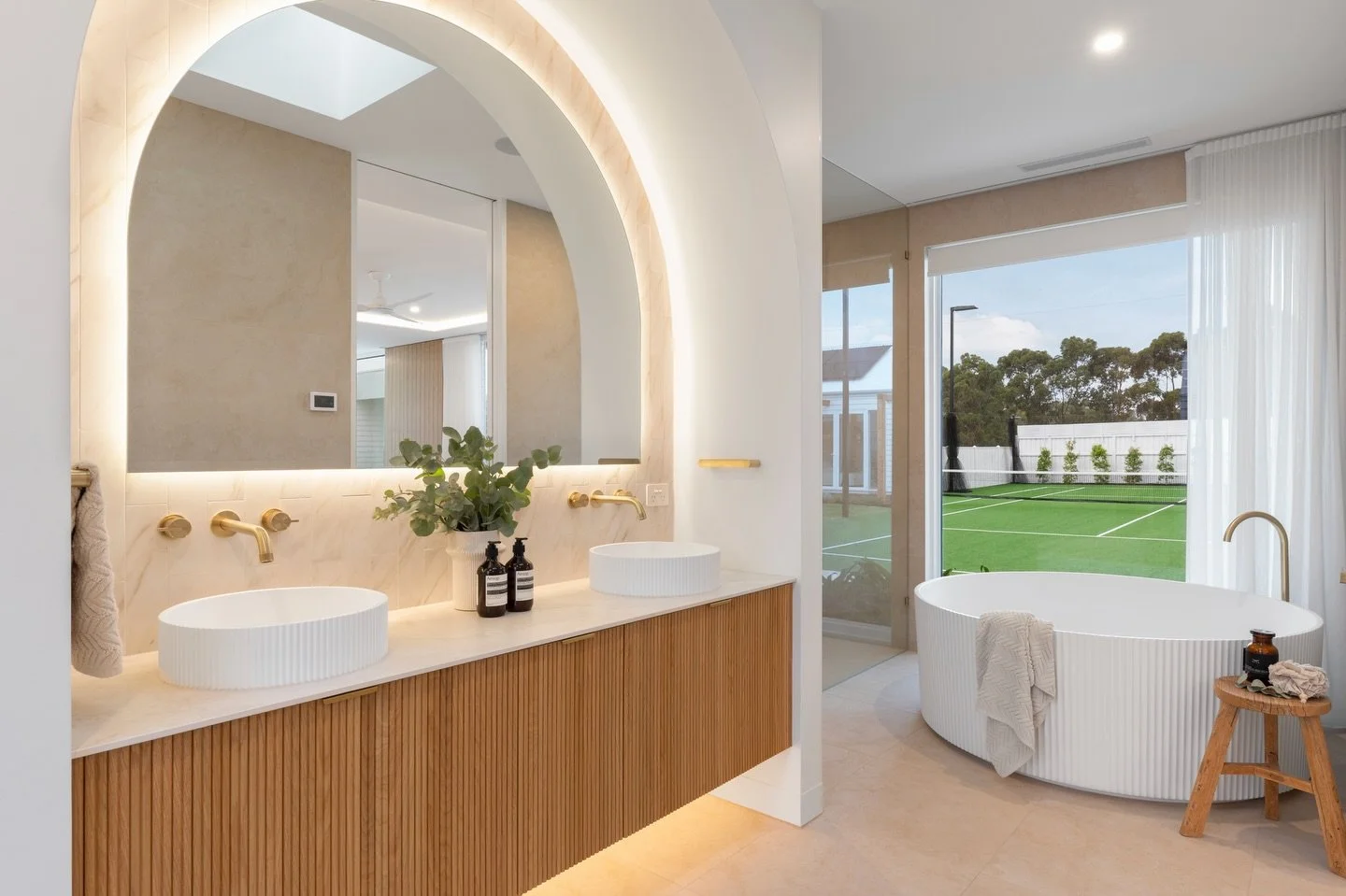 The ensuite at our Haven project is an absolute showstopper ✨

Every detail was designed to elevate the everyday. From the backlit mirror tucked into a curved arch nook, to the warmth of the fluted timber vanity and Carrara Gold feature tiles.

A hug