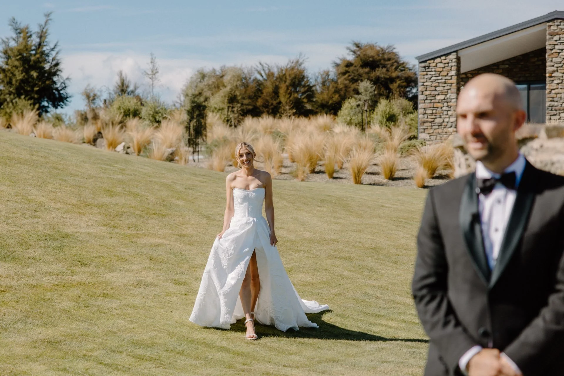A bride walks towards her groom for their first look on the lawn at dublin bay wedding venue