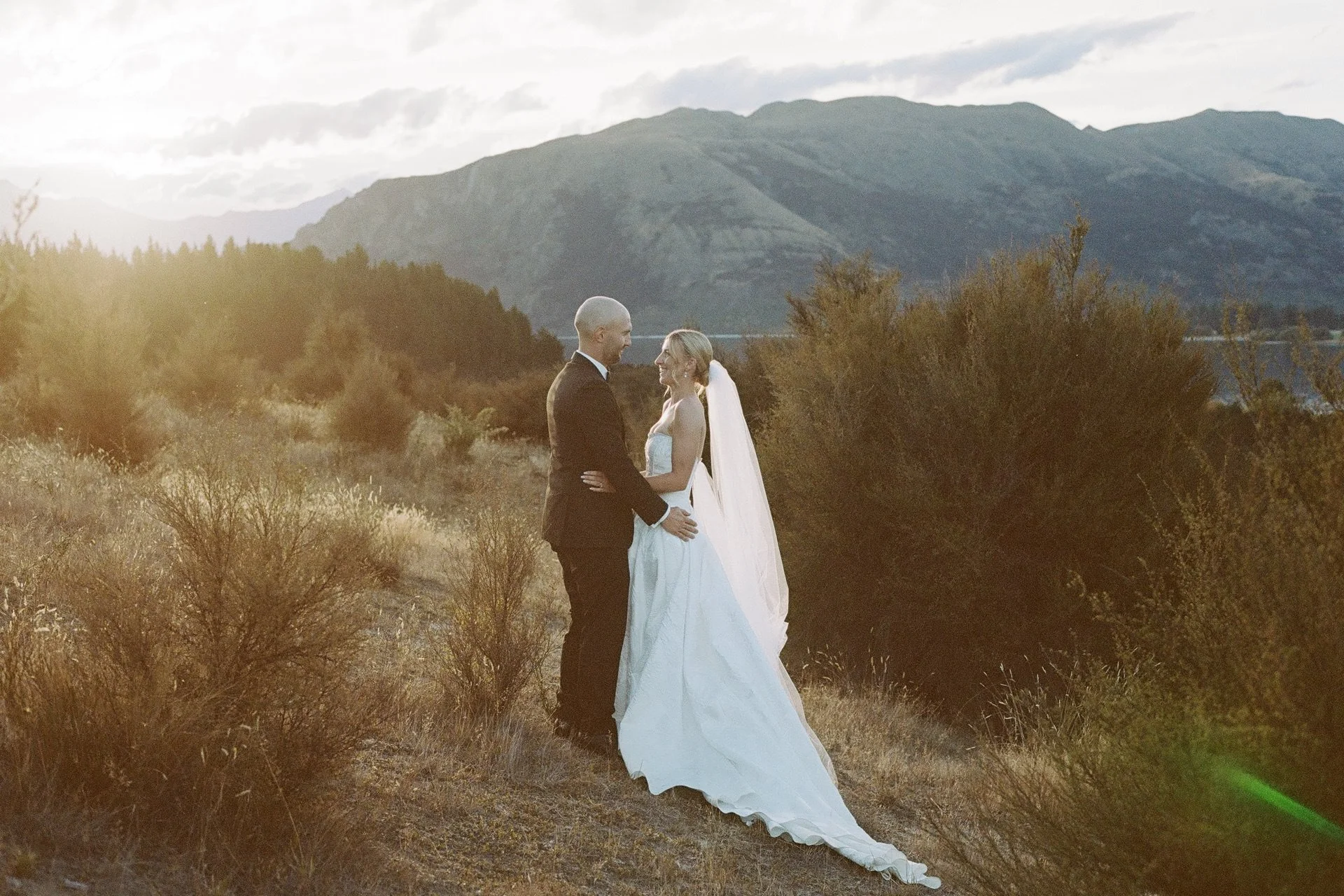 a 35mm film photo of a bride and groom at sunset at dublin bay in wanaka on their summers wedding celebration