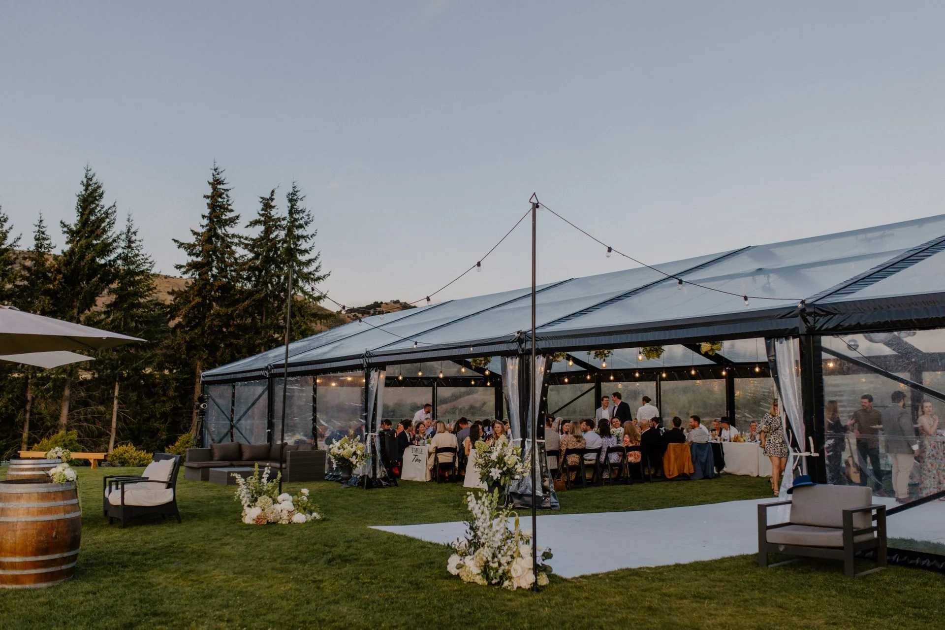 A clear marquee sits at dublin bay wedding venue in wanaka at a summers wedding day.