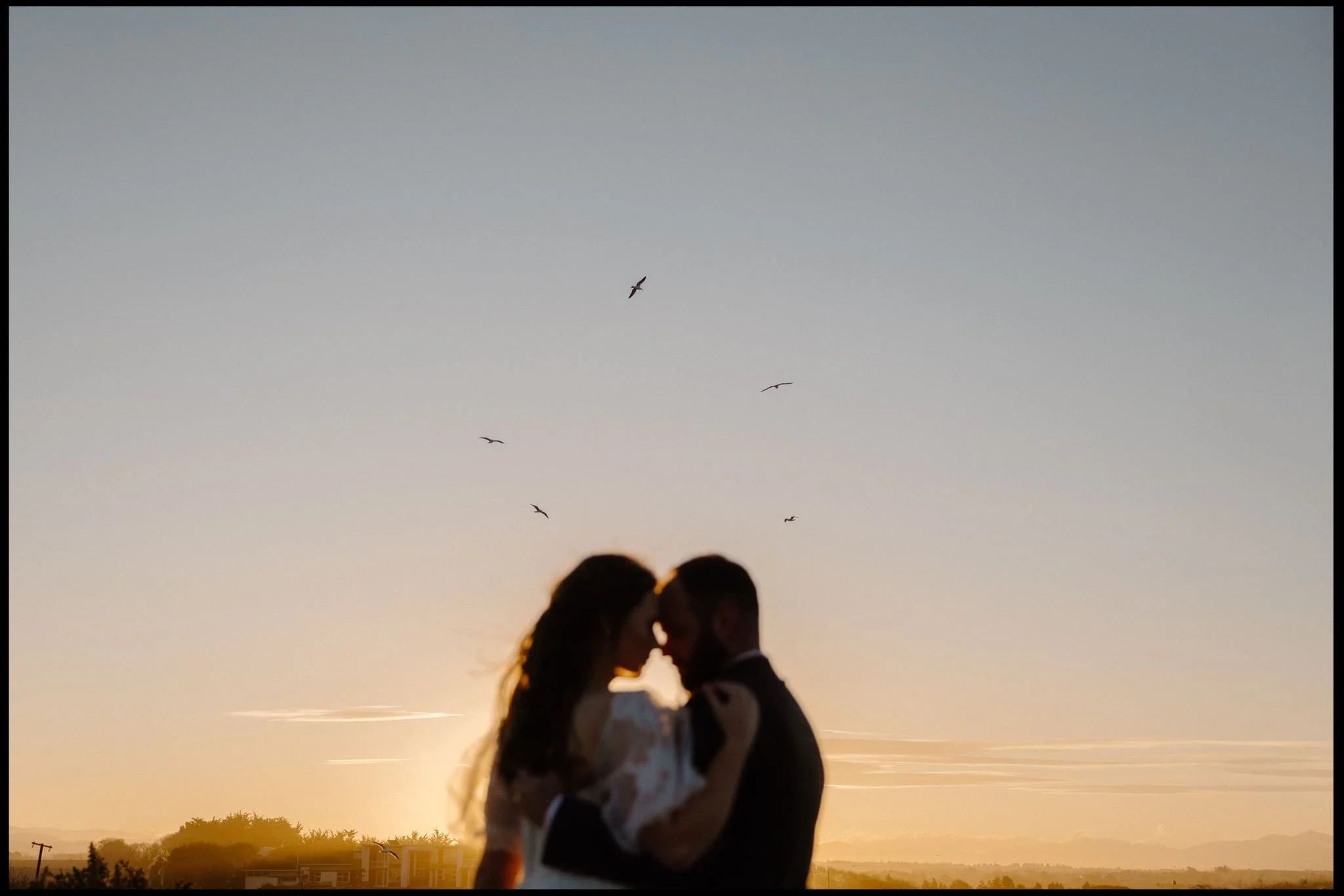 a bride and groom have a quiet moment together at sunset on their wedding day in Timaru