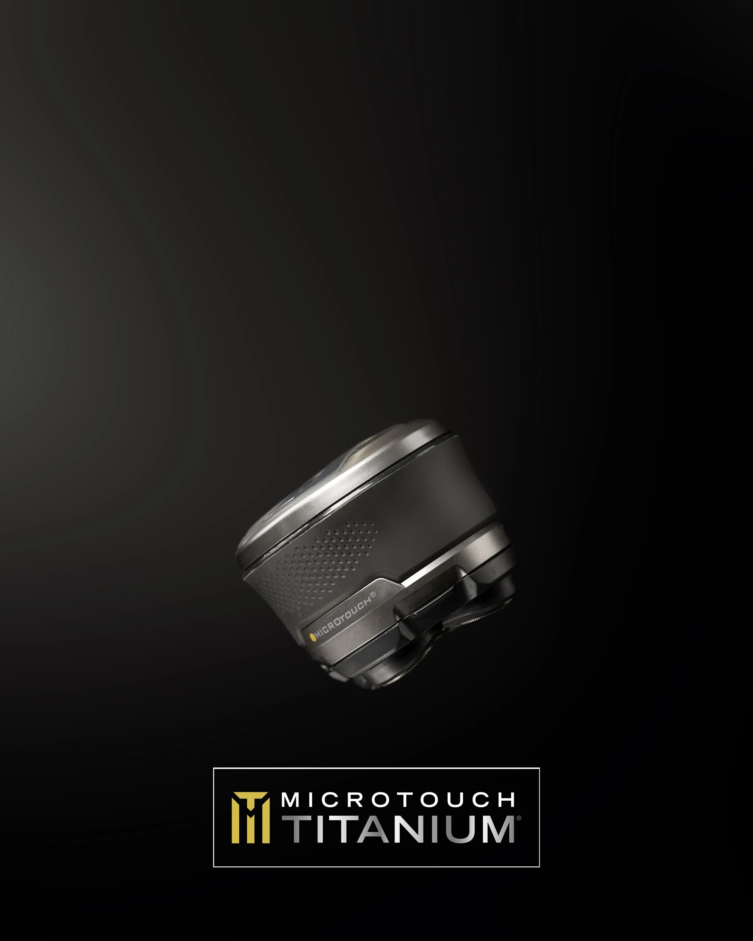 A titanium shaver on a black background with the logo 'Microtouch Titanium' in a black box with yellow and white text at the bottom.