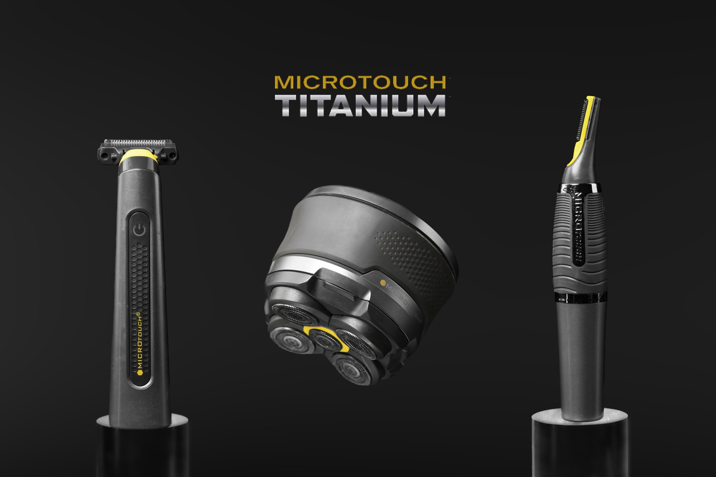 Display of grooming tools including a shaver, a trimmer, and a rotary shaver, all labeled MicroTouch Titanium, on a dark background.