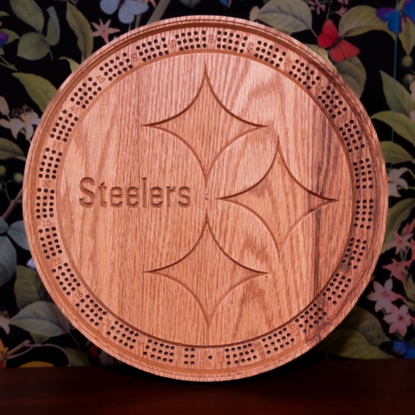 One of our latest custom cribbage boards in the shape of the Pittsburgh Steelers logo. This board features a recessed track for the peg holes and a special engraving on the back.

The Steelers cribbage board is made out of red oak wood and finished w
