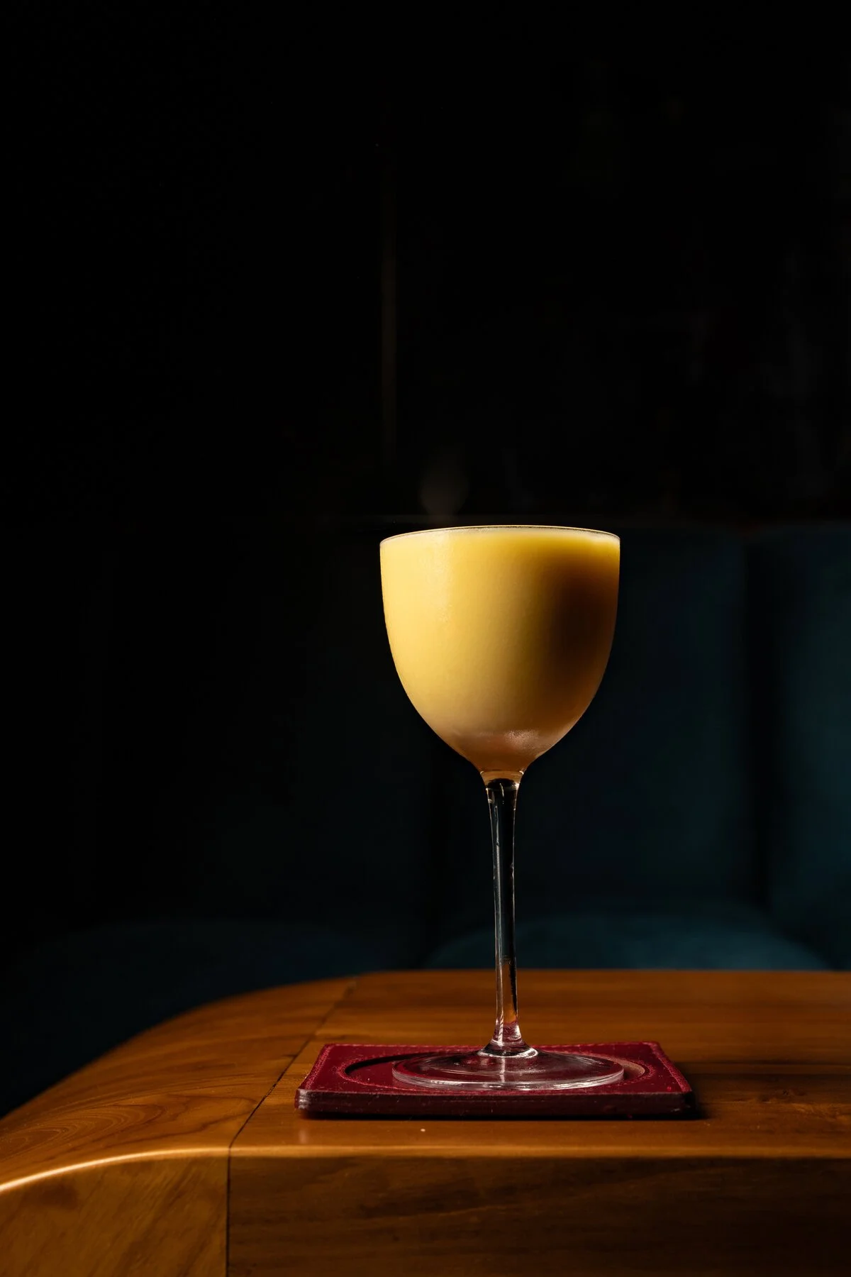 Mango Sticky Rice cocktail on a leather coaster