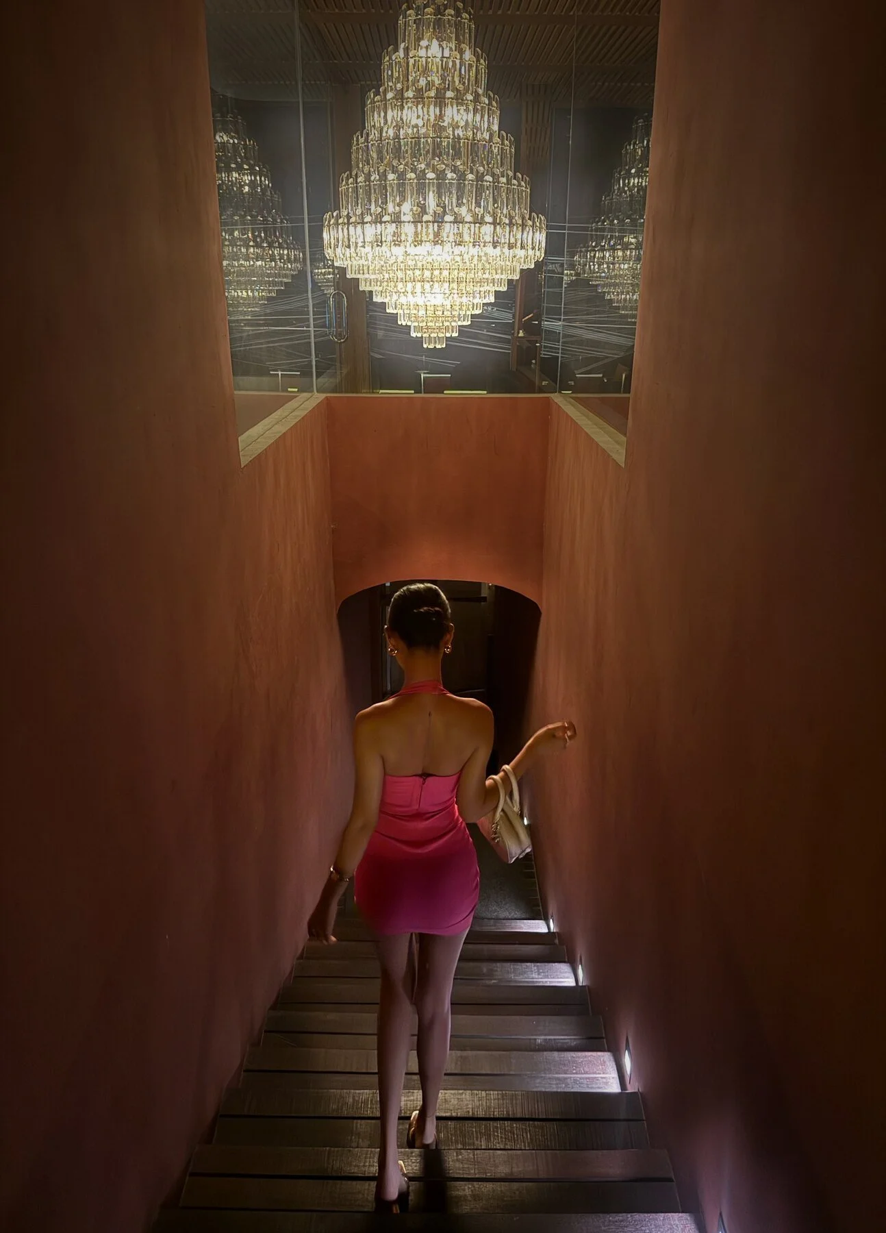 A guest on the White Rabbit staircase, under the chandelier