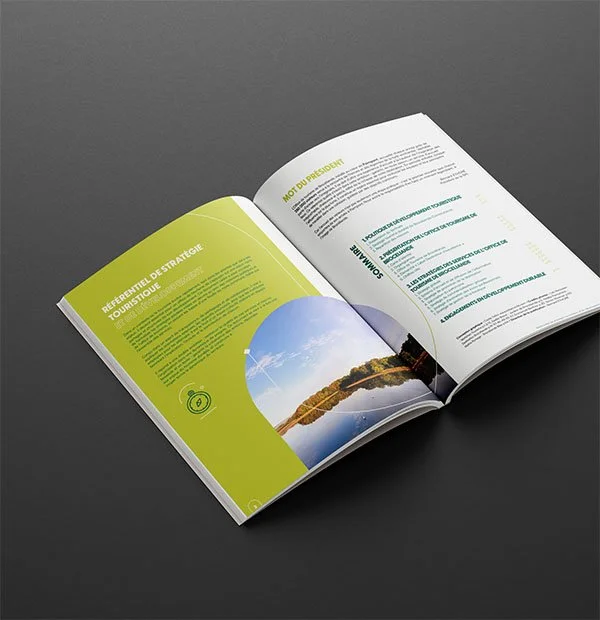 Brochure ouverte avec texte en français et une image d'un paysage avec un lac et des arbres pour l'office de tourisme de Brocéliande à Paimpont.