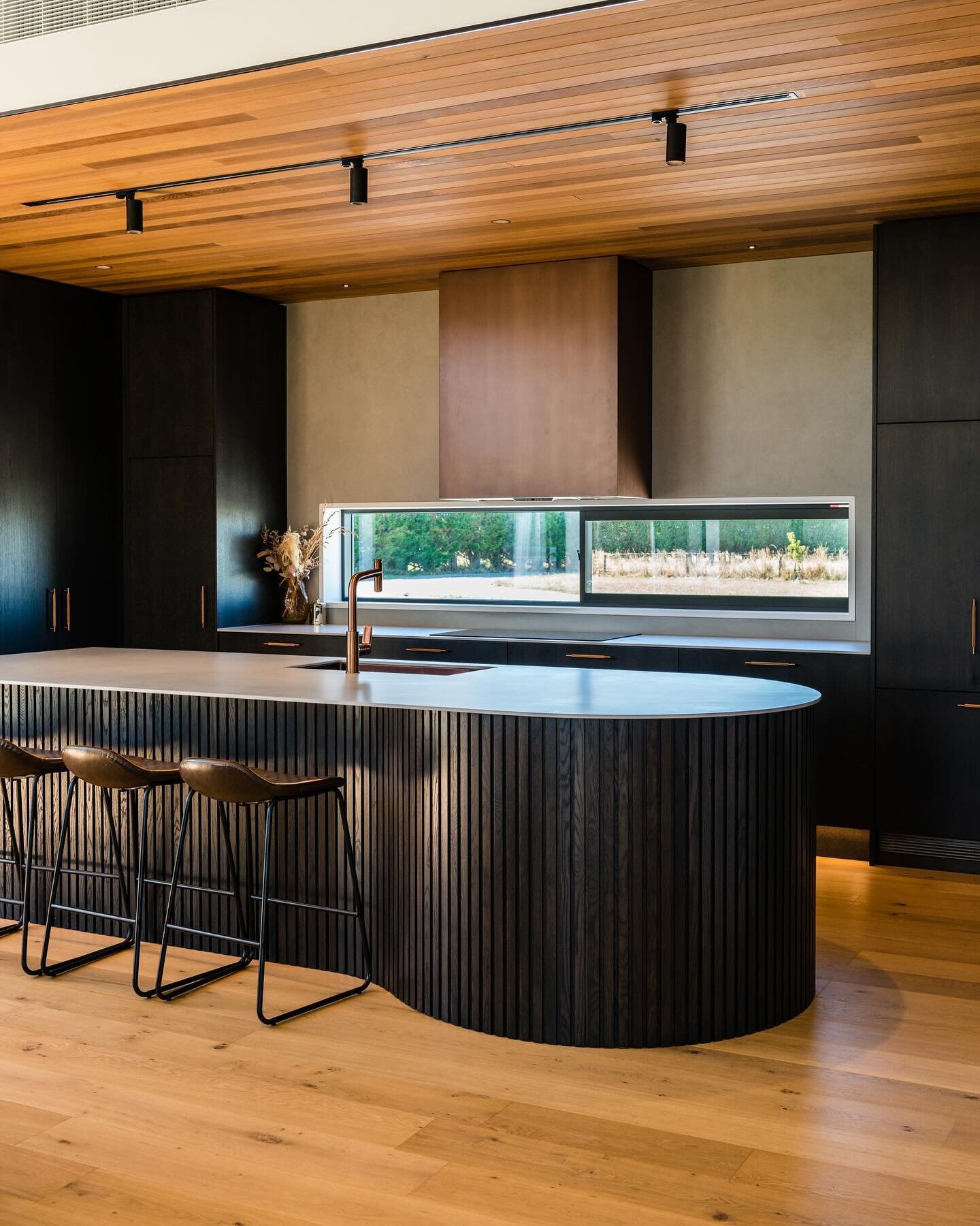 Take a look at our latest project designed and manufactured by the RKJ team ✨

This showstopper kitchen uses a variety of textures to create a dramatic yet cozy feel. The centerpiece of the design is the curved island, featuring Genia timber battens 