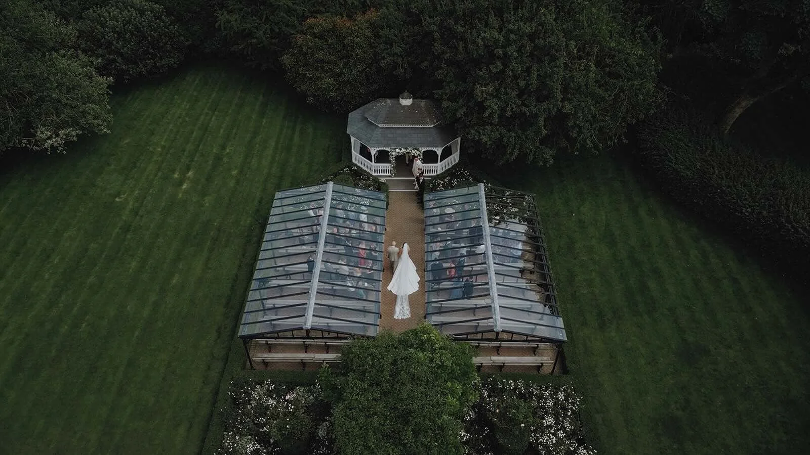 Aerial of Garden ceremony with couple and guests at The Old Kent Barn Wedding Venue