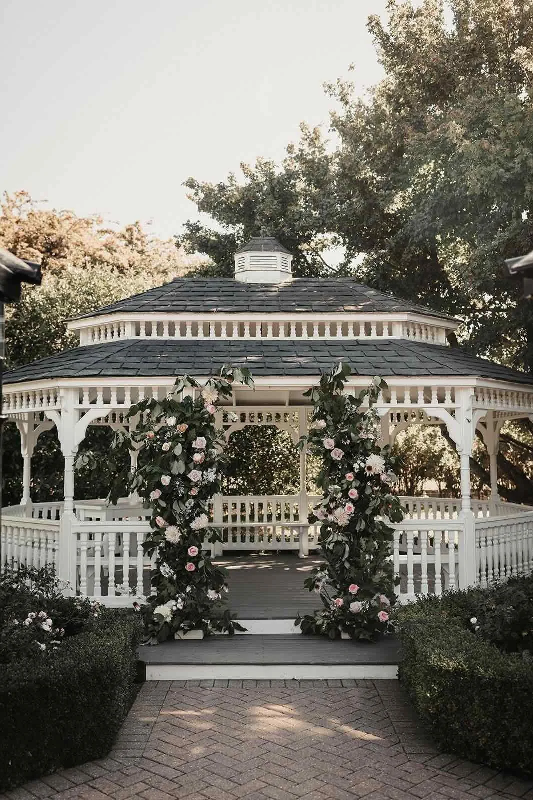 Flower-covered garden ceremony gazebo at The Old Kent Barn