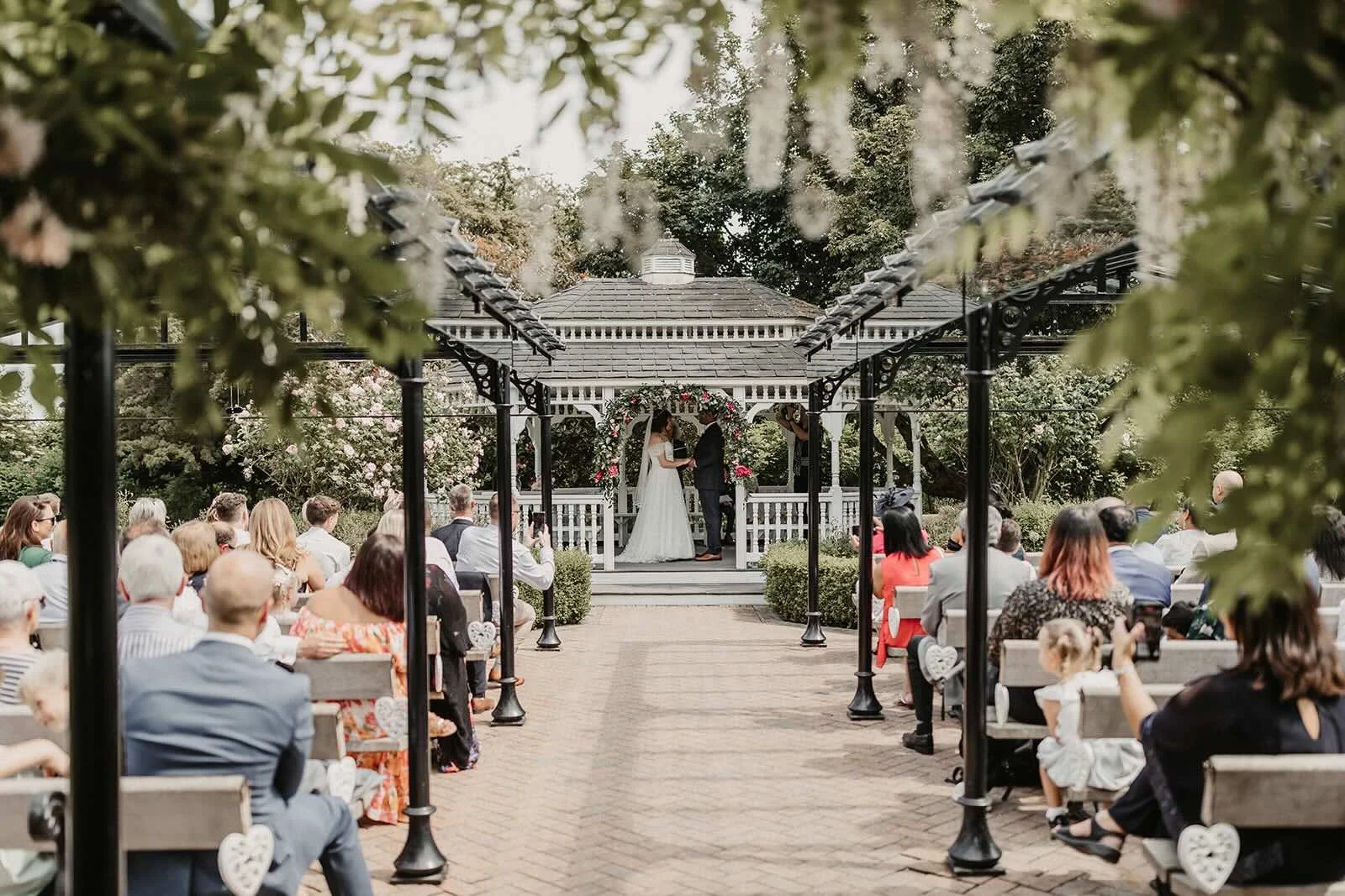 Garden ceremony with couple and guests at The Old Kent Barn Wedding Venue
