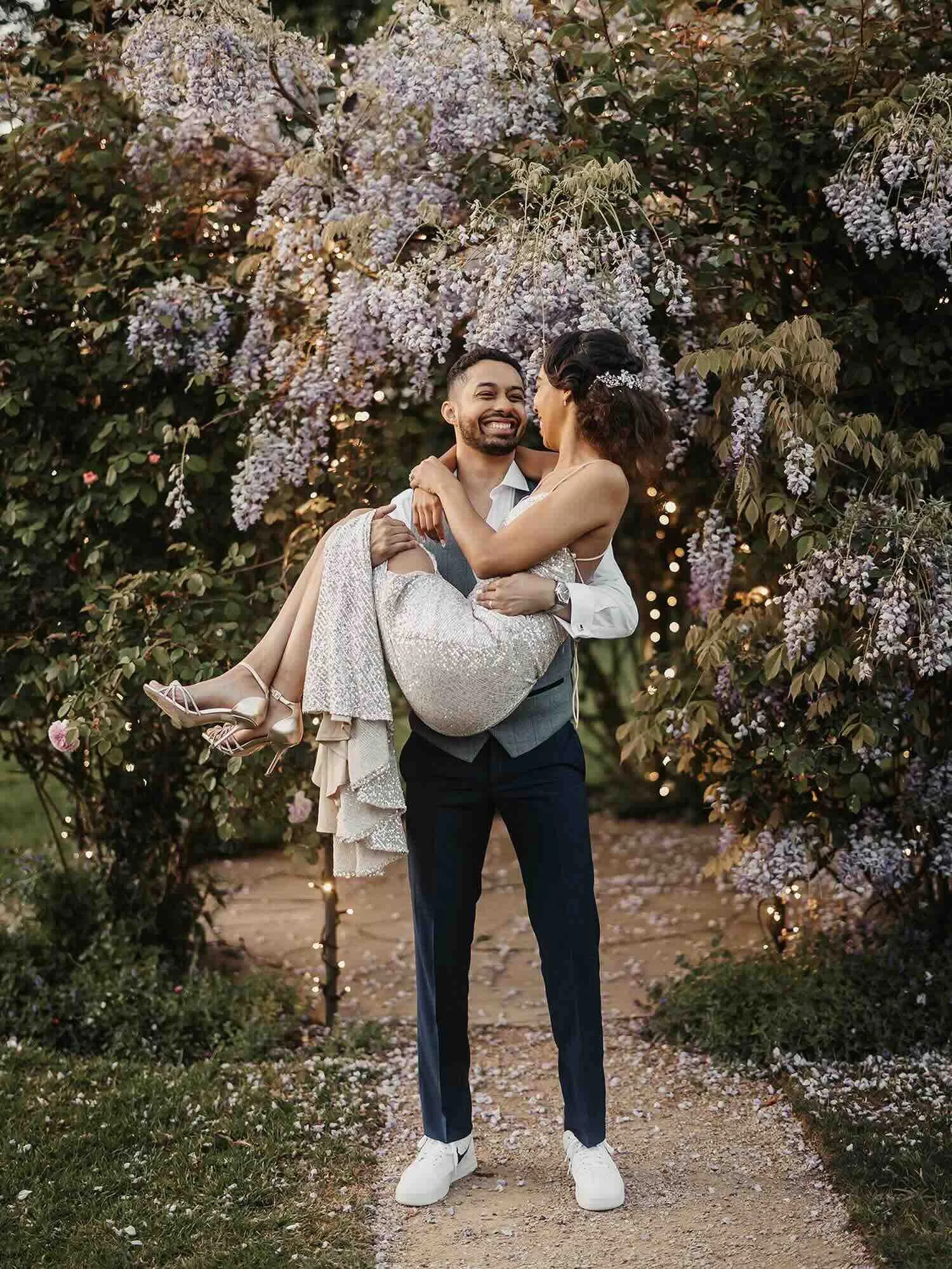 Newlyweds beneath the illuminated wisteria in the evening gardens