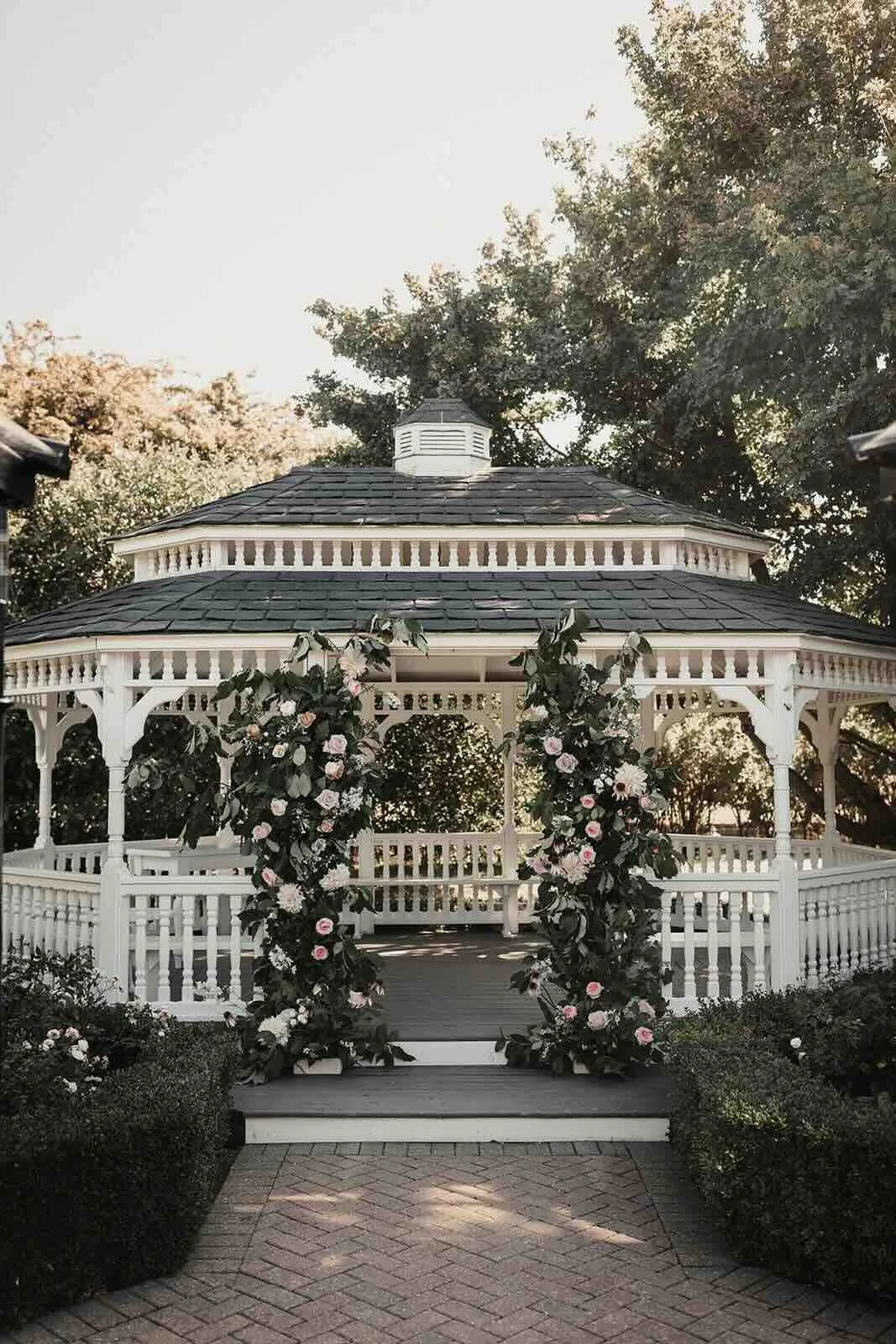 Flower-covered garden ceremony gazebo at The Old Kent Barn