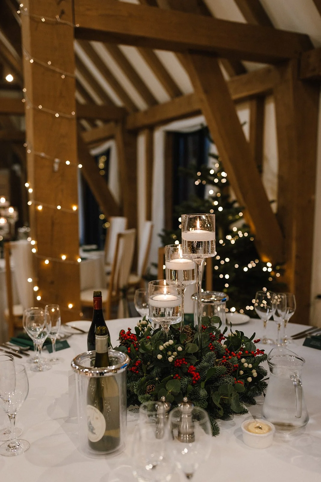 Christmas party venue decorated with fairy lights and fir trees at The Old Kent Barn