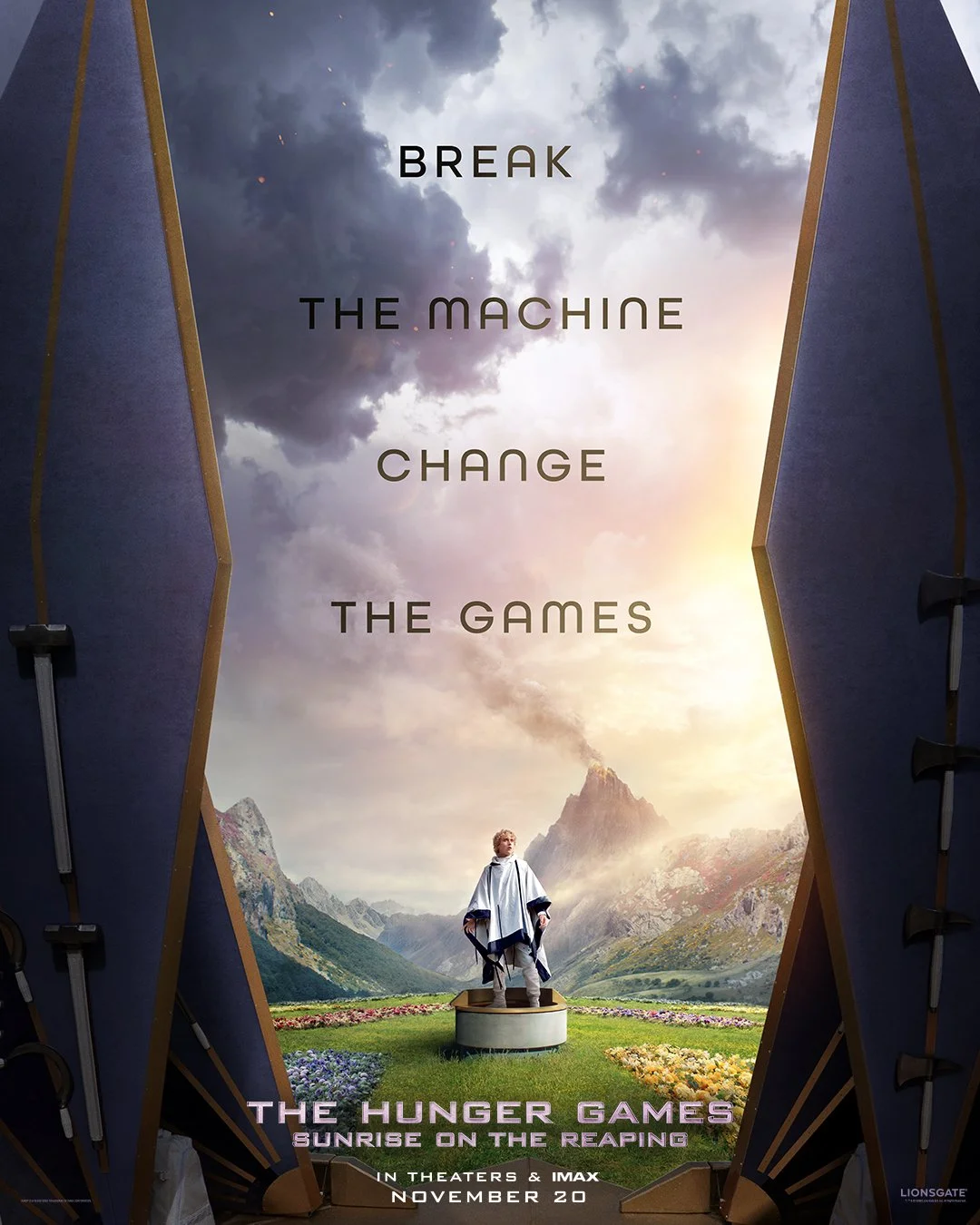 A promotional poster for The Hunger Games: Sunrise on the Reaping, featuring a mountainous landscape with a person standing on a pedestal, and the slogan 'Break the machine, change the games.'