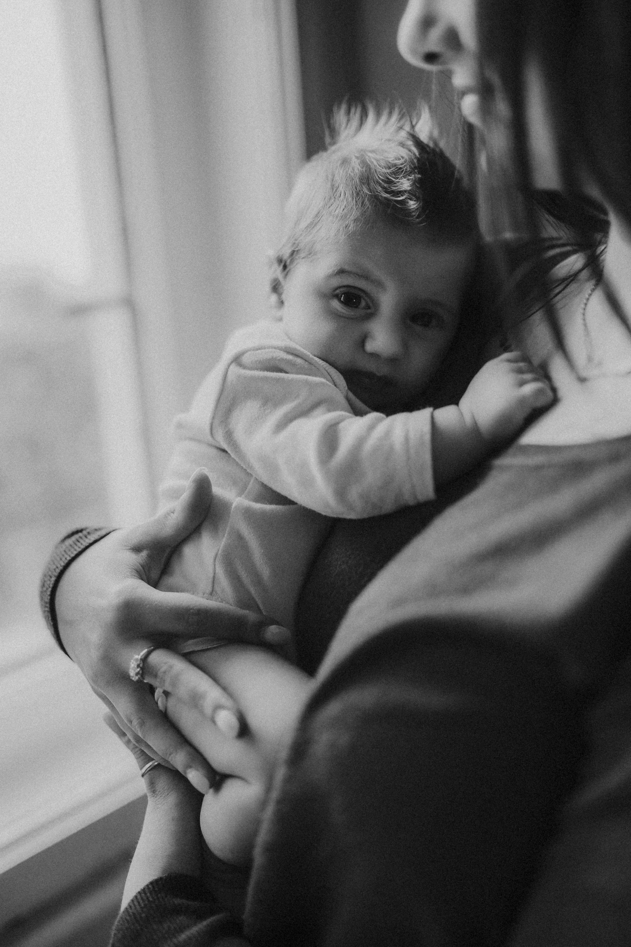 Bambino che si aggrappa a una donna, probabilmente sua madre, mentre si trova in braccio a lei. La scena è in bianco e nero.