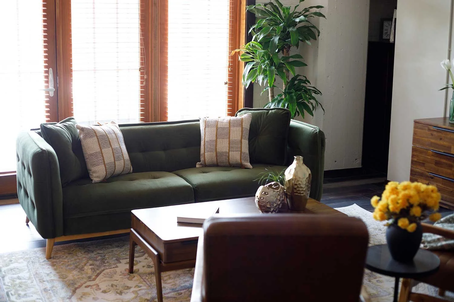 Green sofa, coffee table and rug available for rent at Abode by Furniture Options