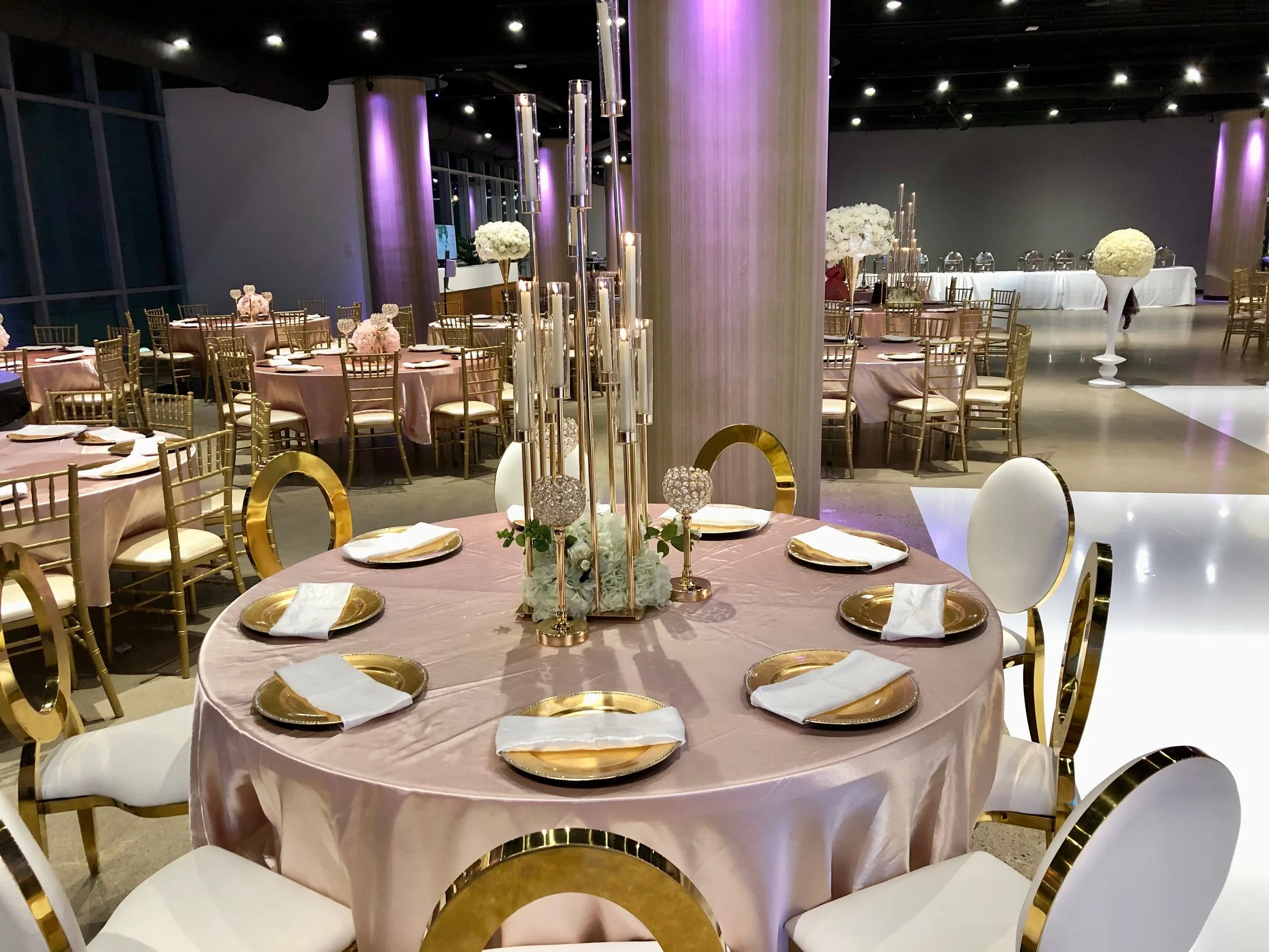 St. Paul Event Center Tables with Gold Decoration Tall Candles and White Chairs.jpg