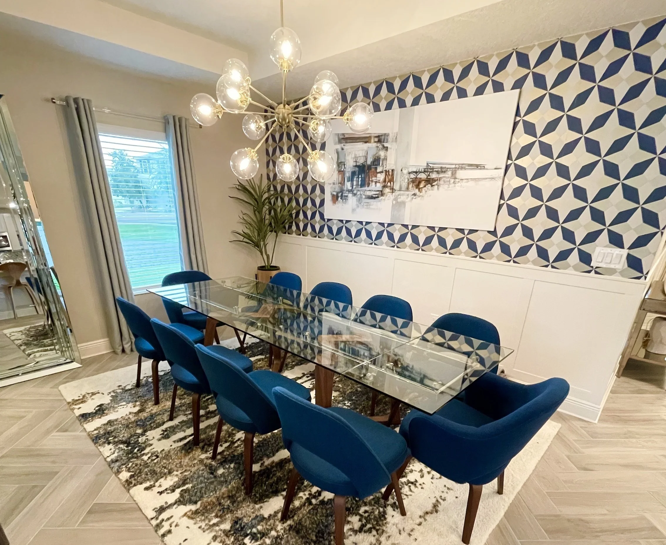 A dining space featuring a mix of bold patterns, sculptural lighting, and modern eclectic furniture.