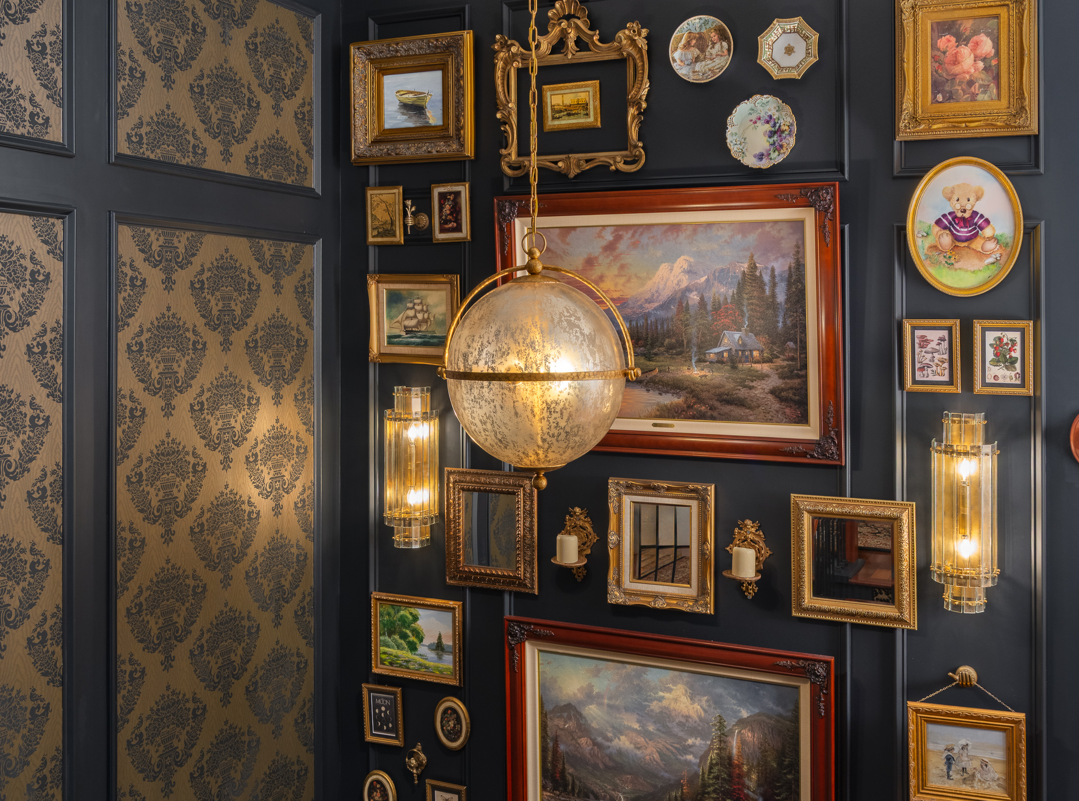 A wall displays a collection of framed paintings, plates, and decorative items, including a large globe-shaped pendant light.