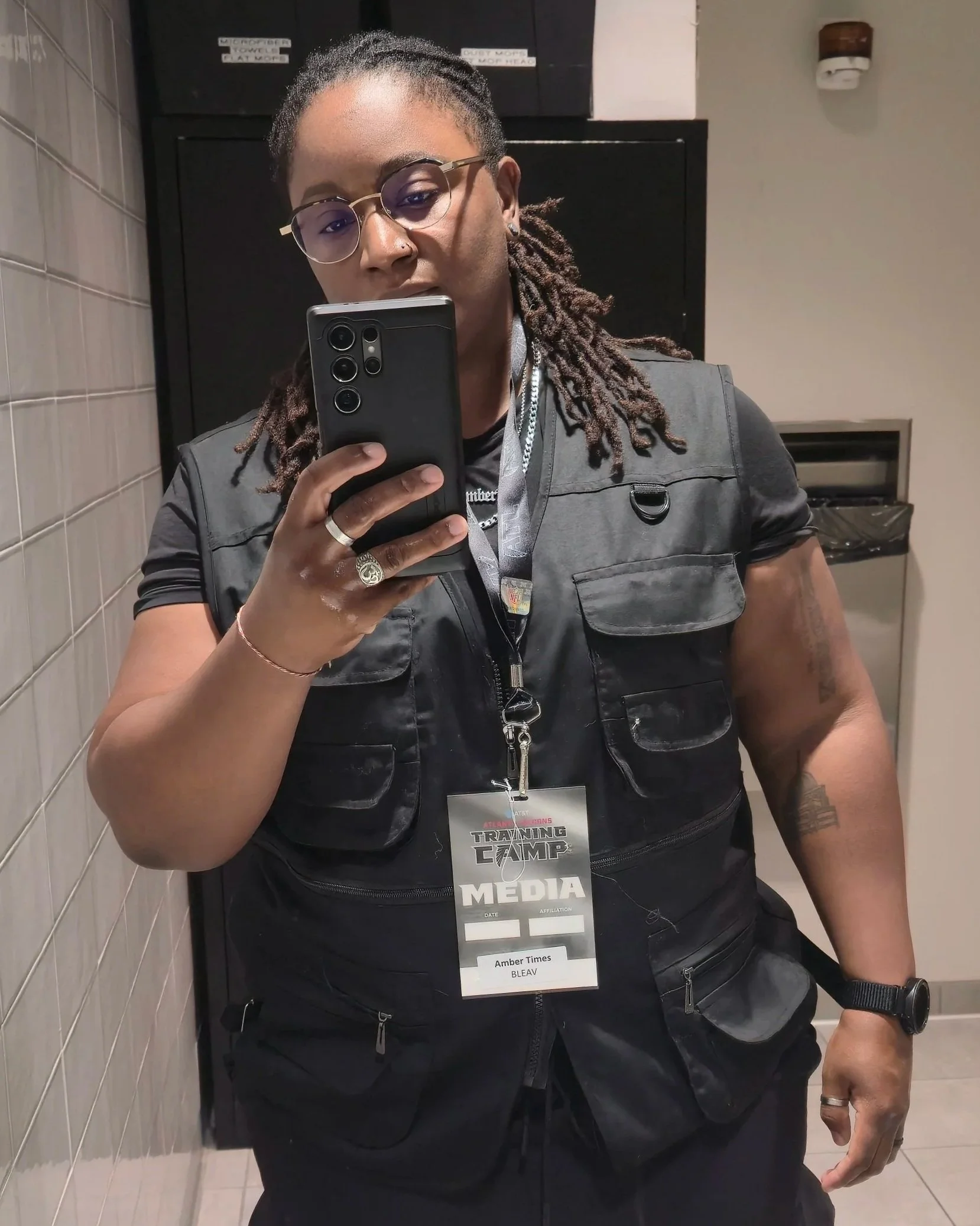 Amber Times wearing her media credential and photography vest at Falcons Training Camp, preparing to capture on-field action and fan experiences.