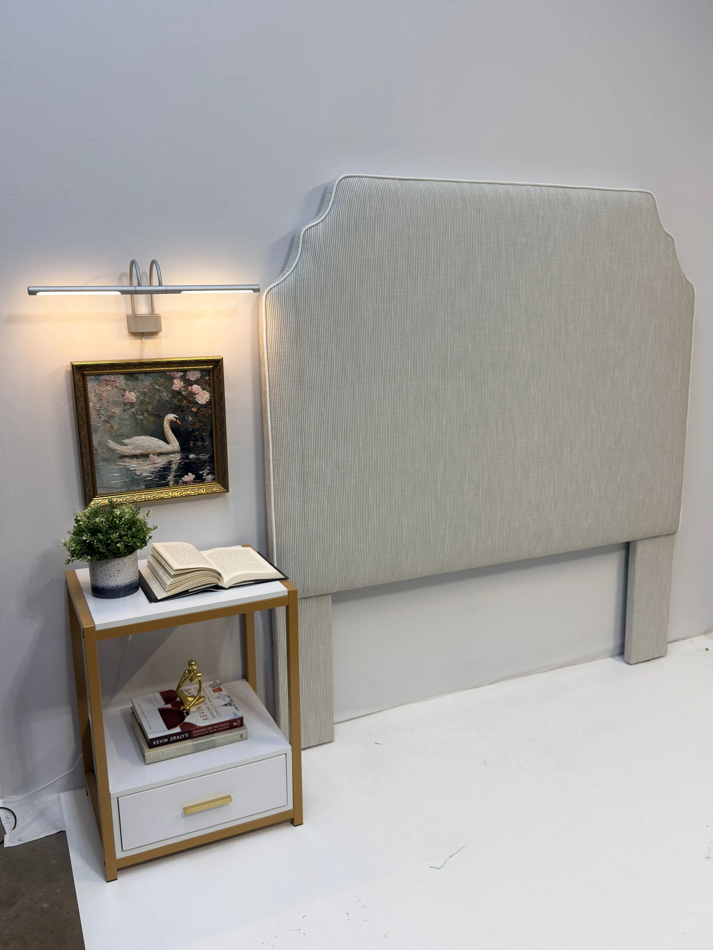 A room with a sophisticated claddagh / notched corner silhouette Queen size upholstered headboard with a beautiful crips white piping.