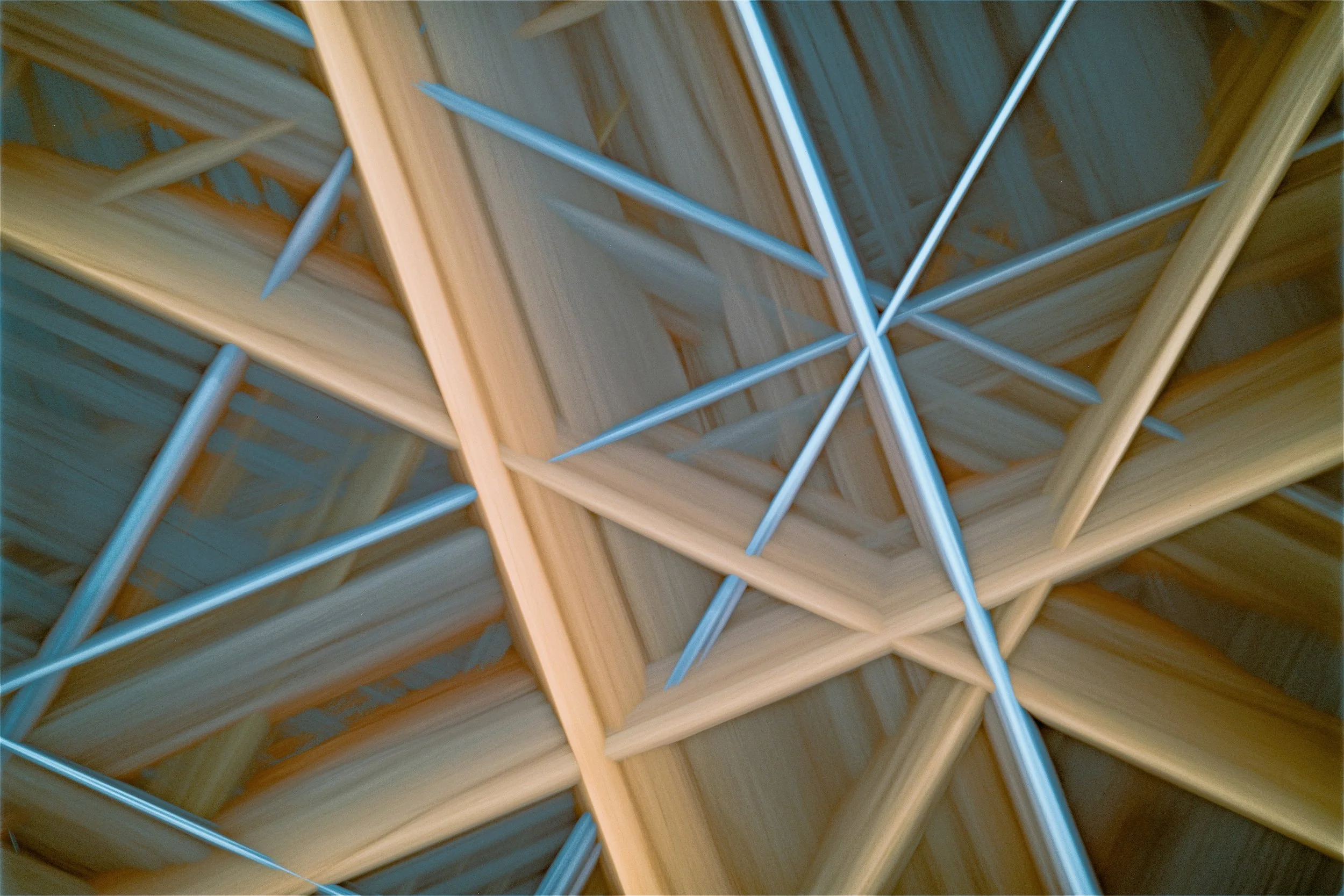 An abstract arrangement of intersecting wooden and metallic structural pieces.