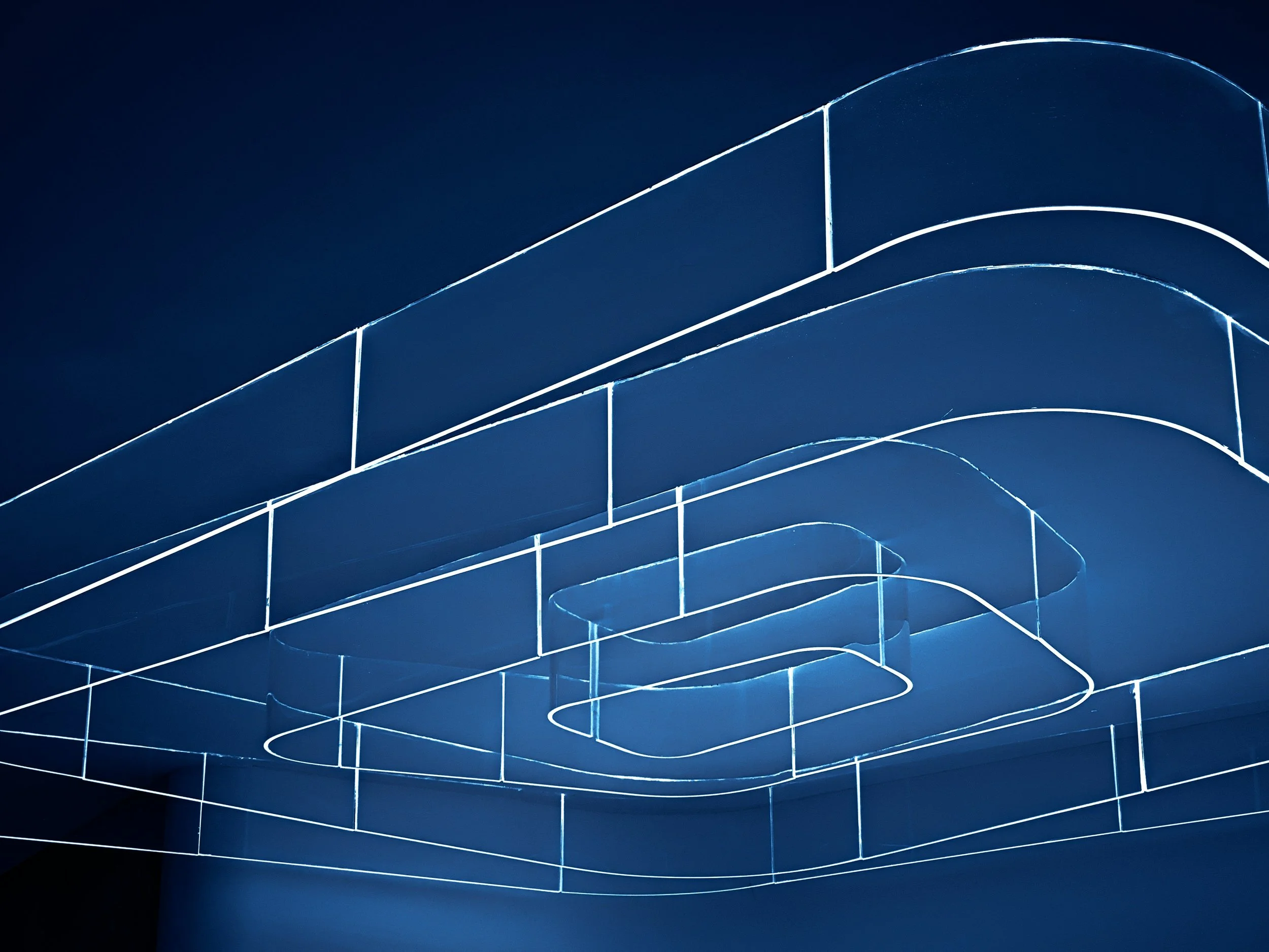 Abstract blue architectural lines forming a layered building-like structure against a dark background.