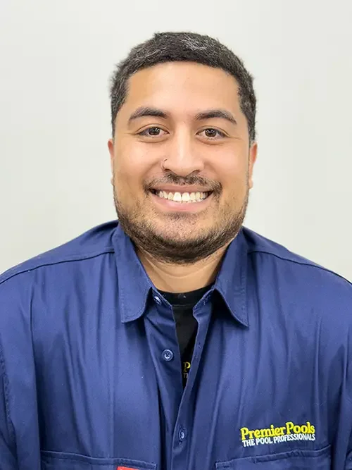 Portrait of a man smiling, wearing a dark blue shirt with a logo that says Stabil Pools, standing against a plain light-colored background.