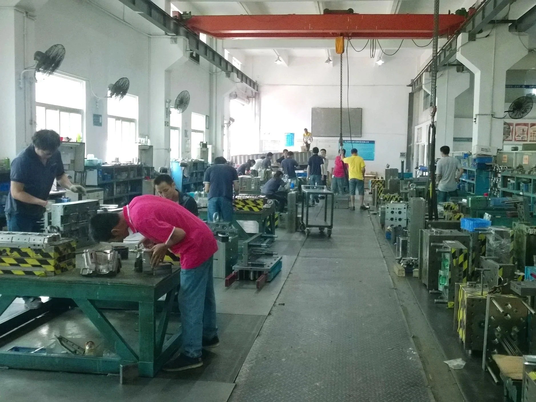 Industrial manufacturing floor with equipment and workers for production setup