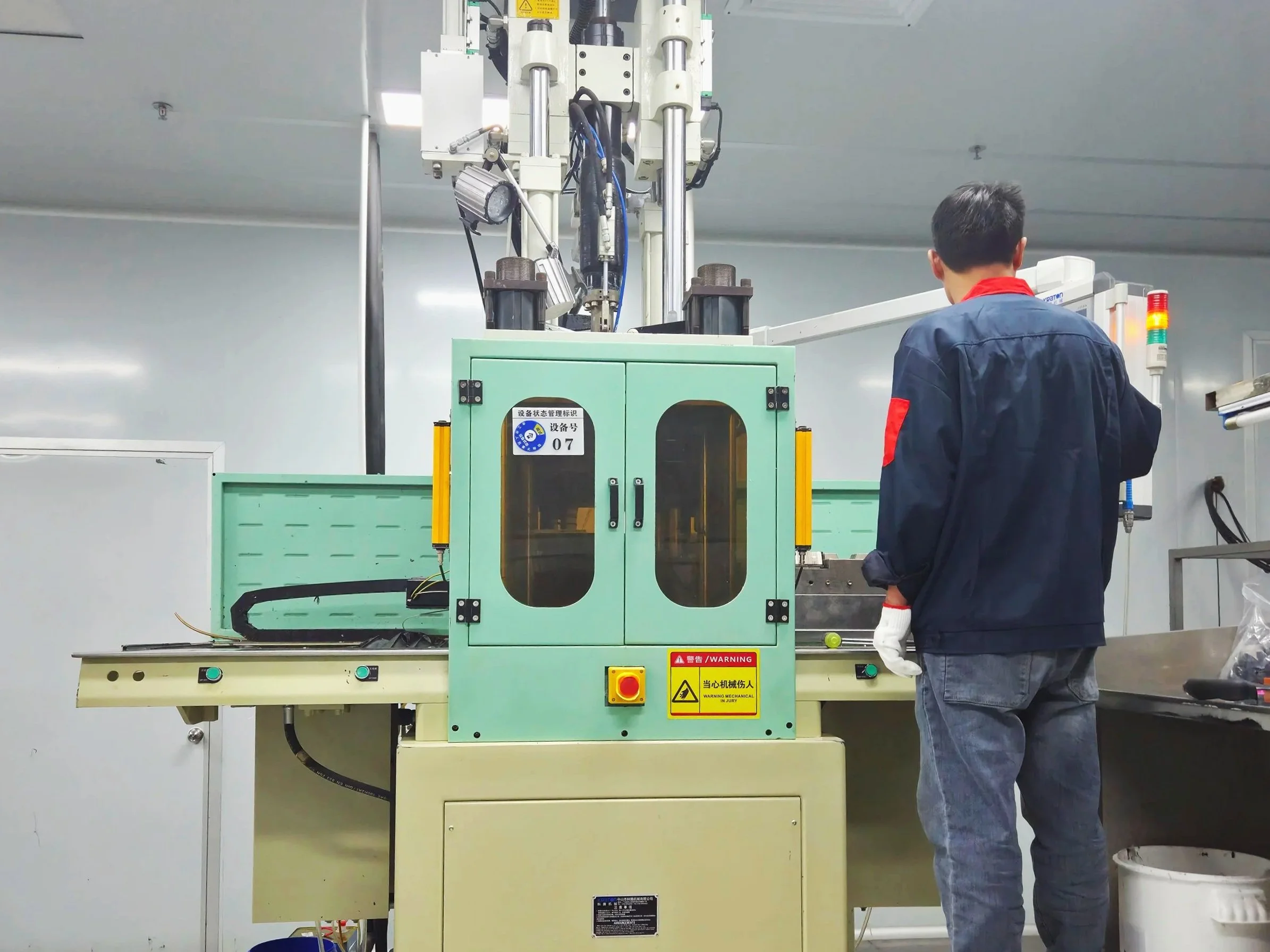Technician operating injection molding machine for precision parts manufacturing
