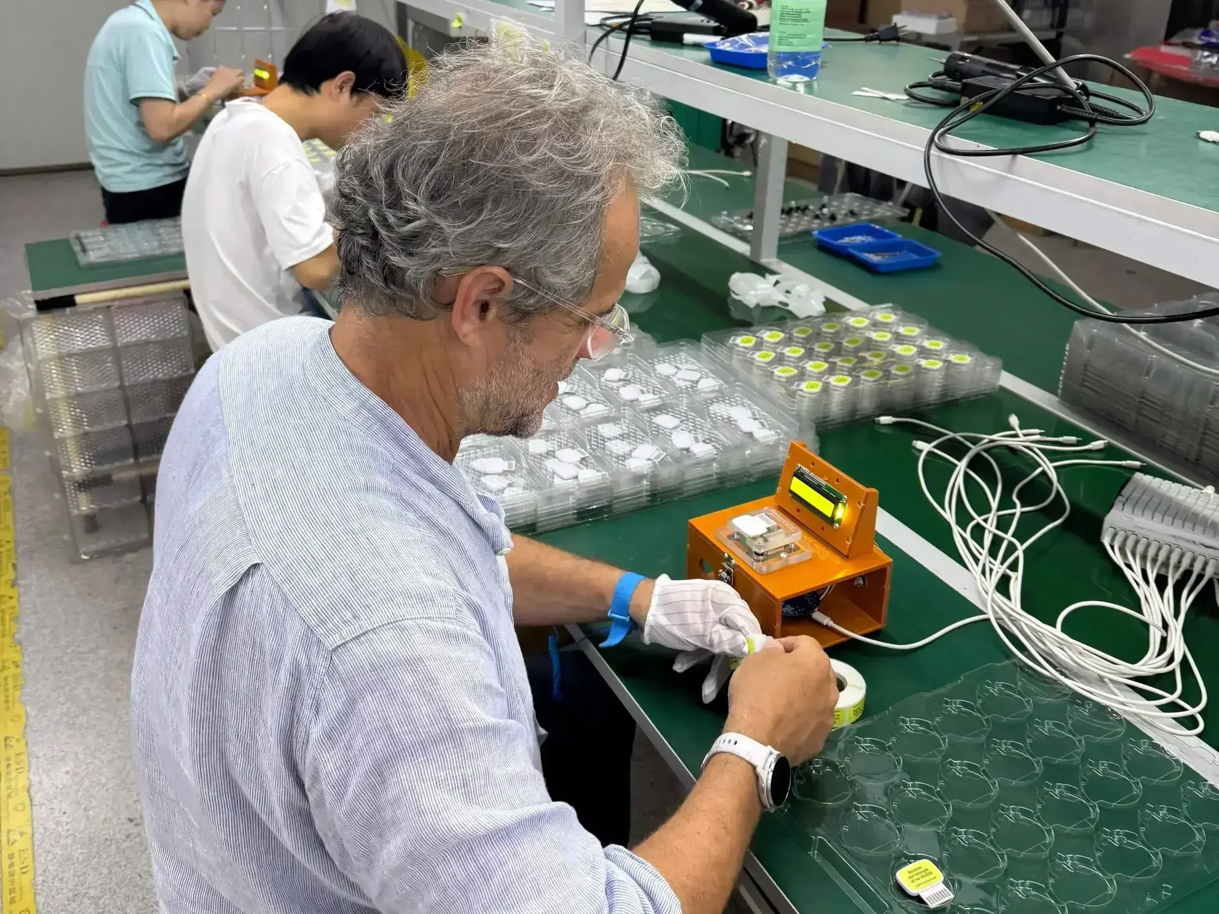Quality control operator testing electronics at TEKTOS manufacturing assembly station