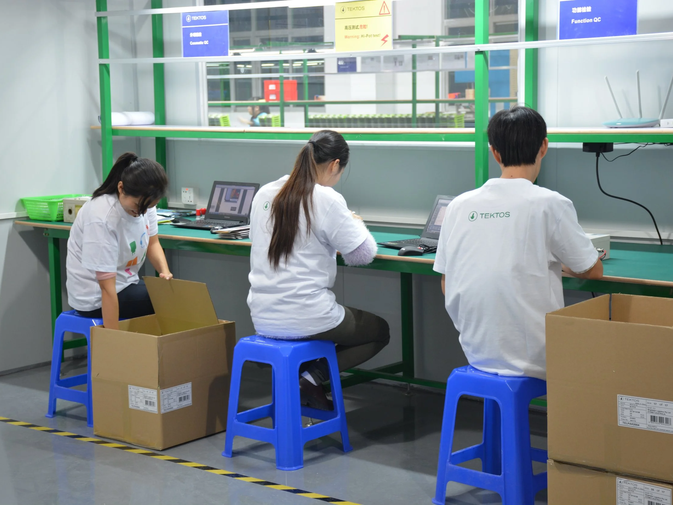 TEKTOS assembly line workers at ergonomic workstations with quality control systems