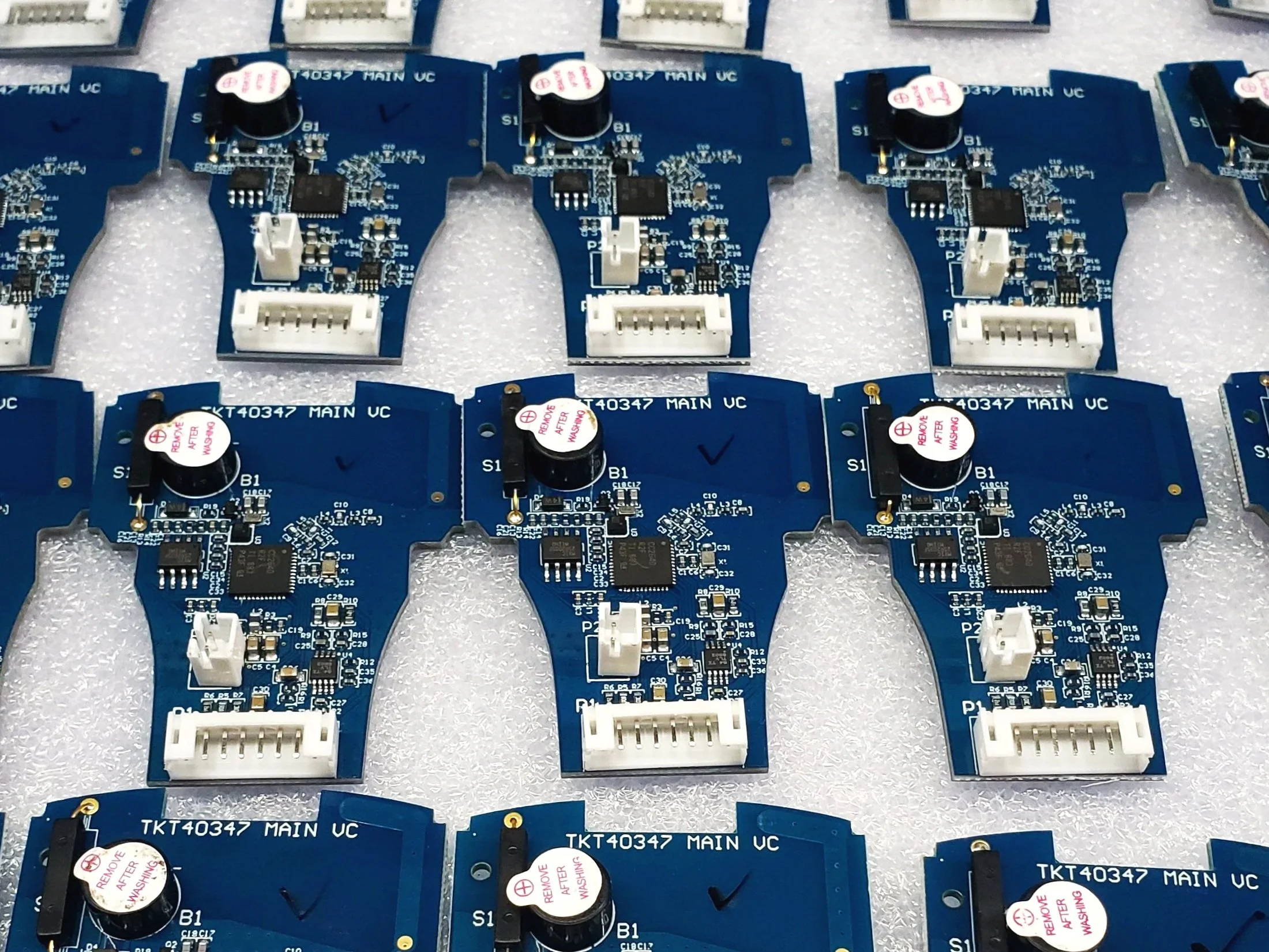 Blue circuit boards arranged for mass production and automated testing processes