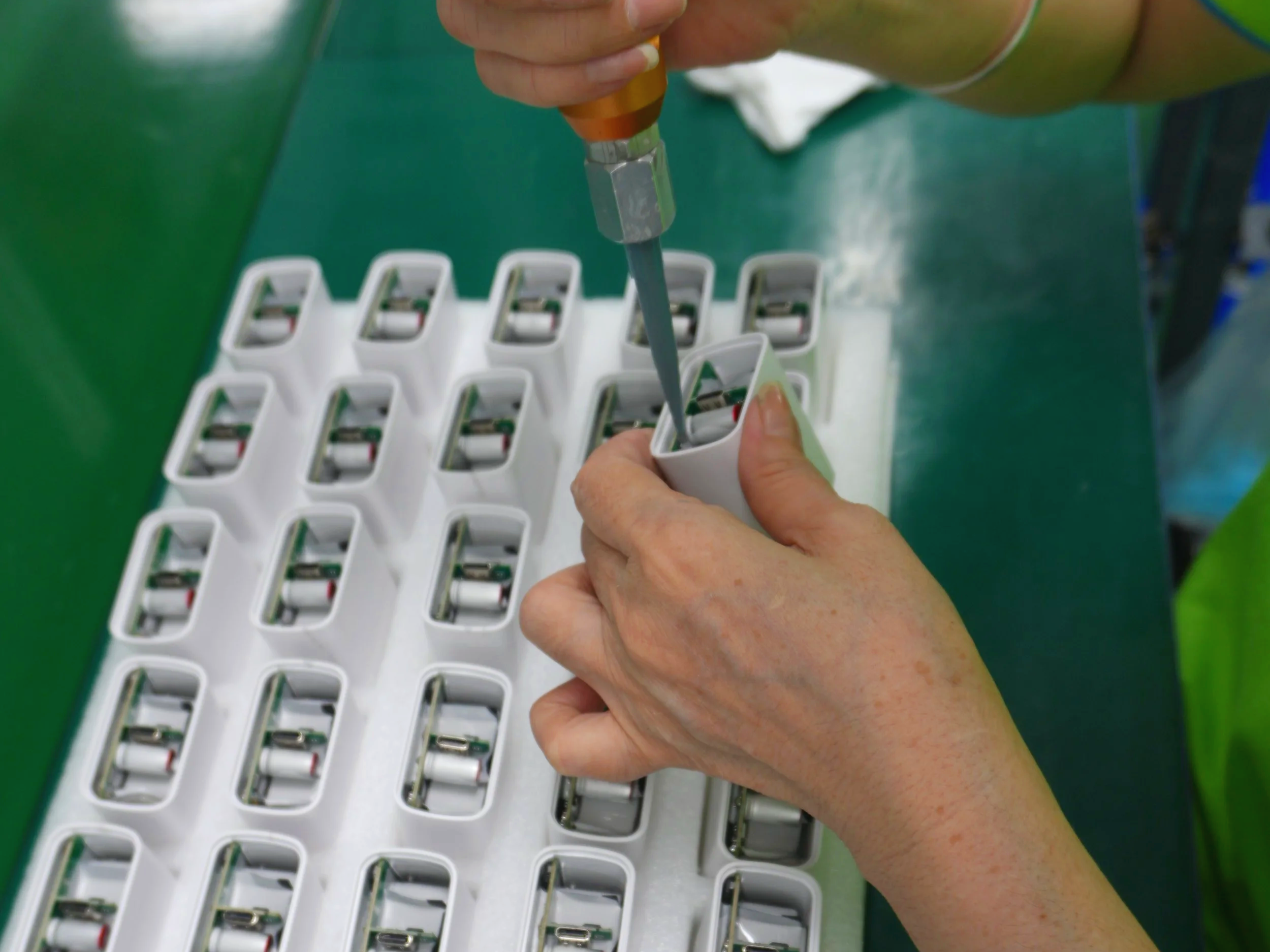 Worker inspecting electronic components panel for mass production quality assurance