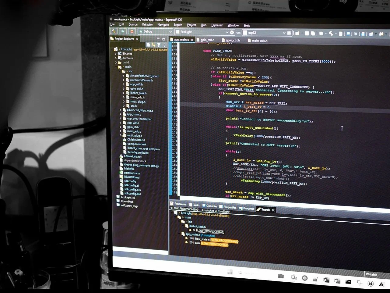 Developer writing embedded firmware code on dual monitor workstation setup