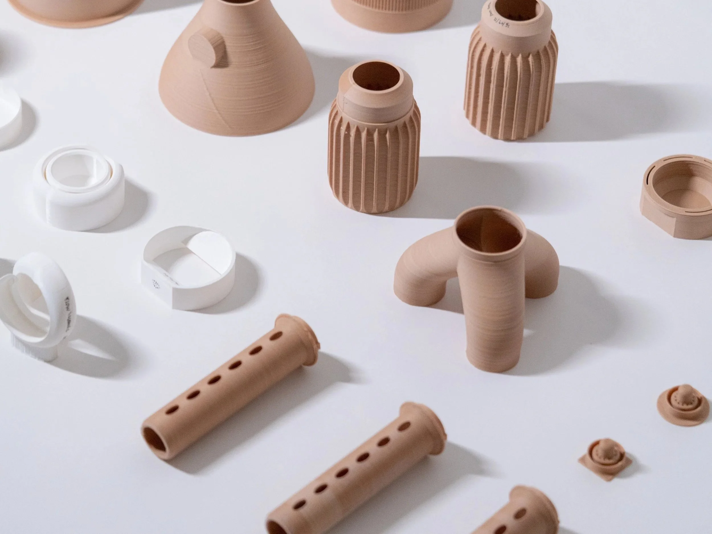 Collection of industrial design prototypes and material samples in natural tones