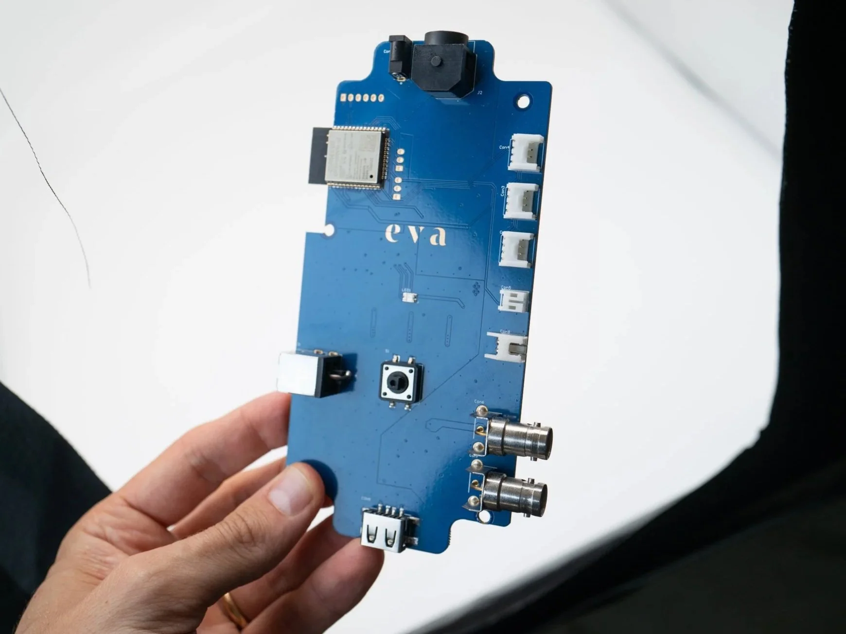 Hand holding blue electronic device with embedded firmware and connectivity features