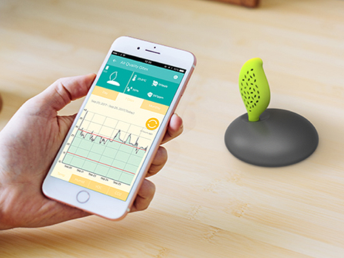 Hand holding smartphone displaying IoT app connected to wireless sensor device