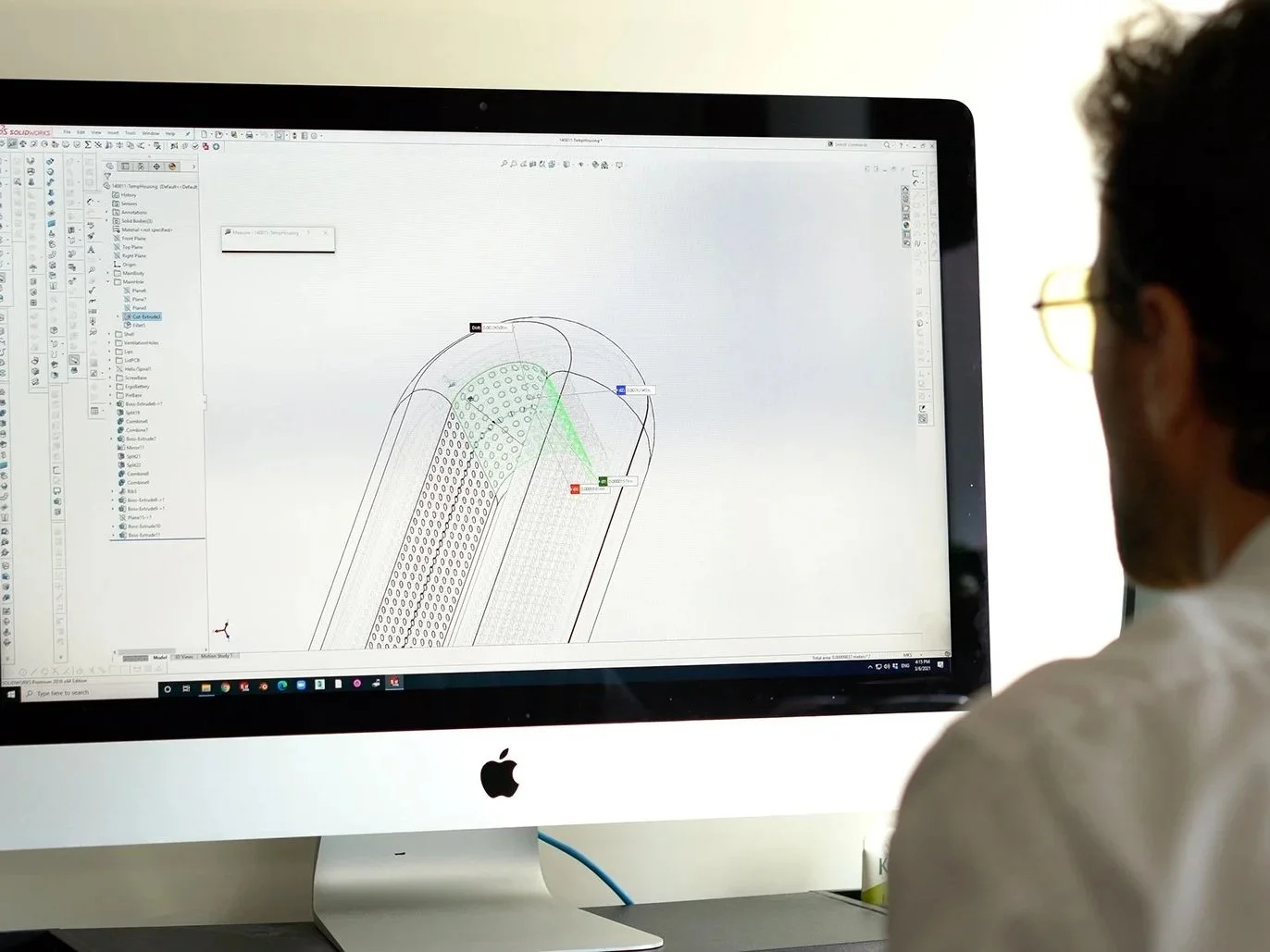 Designer working on 3D CAD model for industrial product design on computer screen