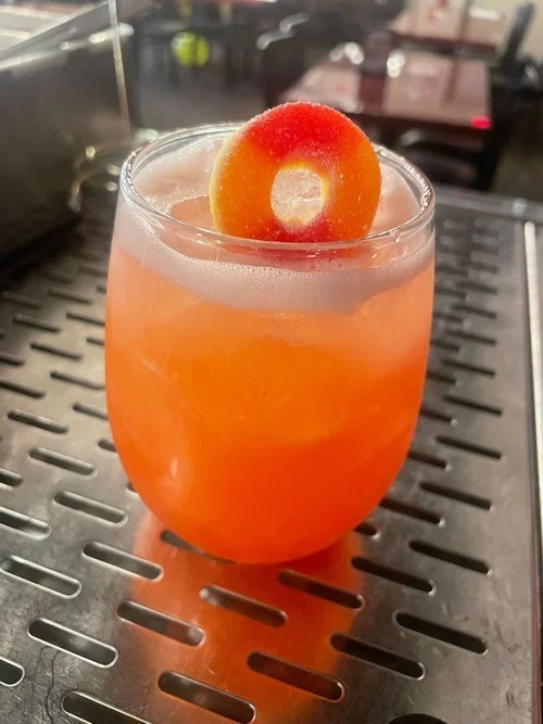 A delightful blend of peach schnapps, vodka, orange juice, and cranberry juice, served over ice with a candy garnish at Battle & Brew.